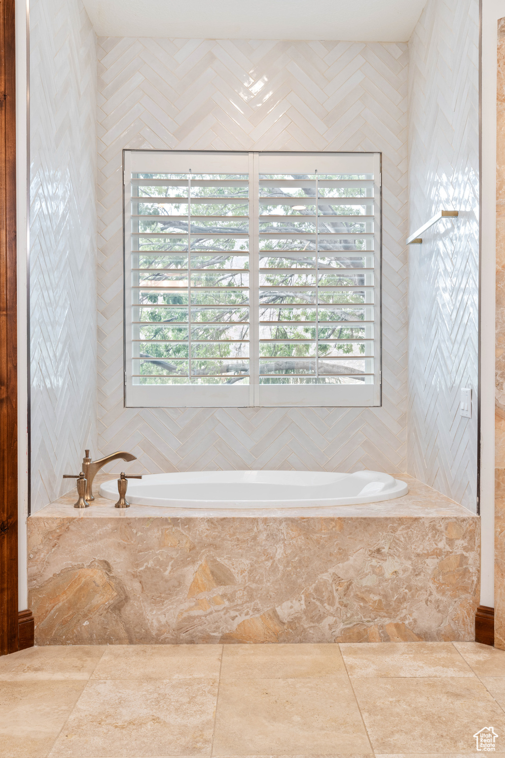 Bathroom with a wealth of natural light and tiled tub