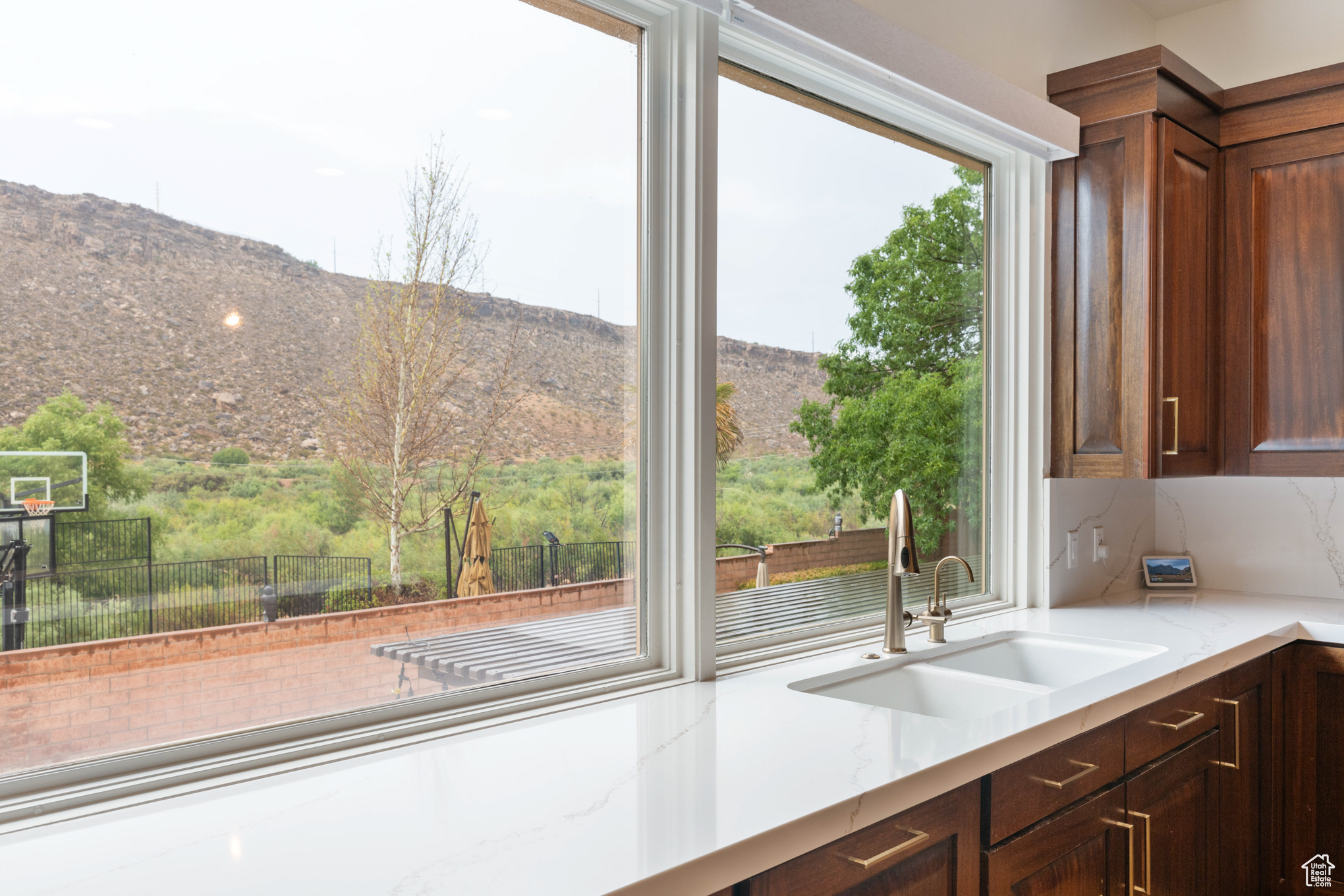 Kitchen with a mountain view, light stone countertops, and sink