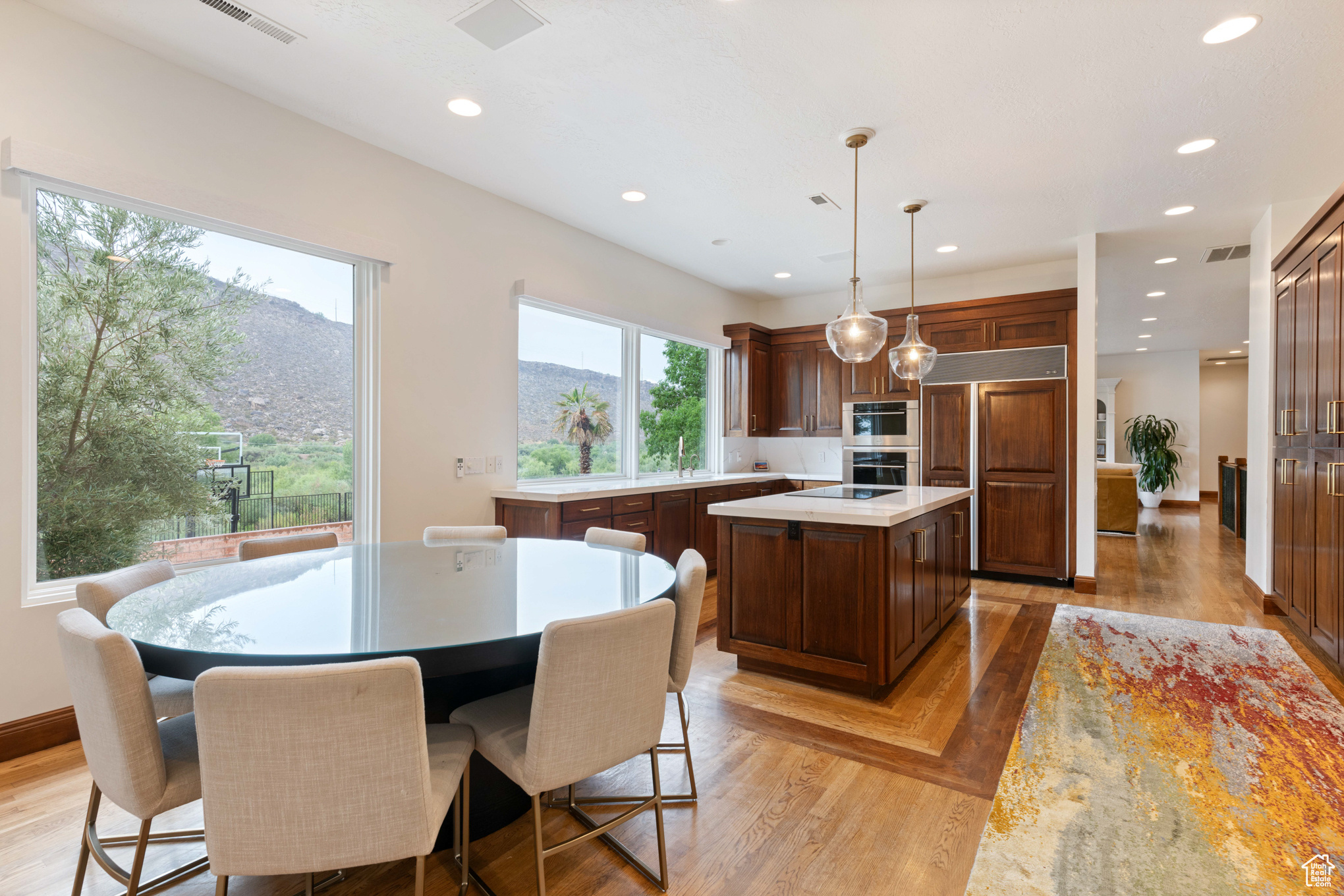 Kitchen featuring paneled refrigerator, pendant lighting, light hardwood / wood-style flooring, a mountain view, and a center island