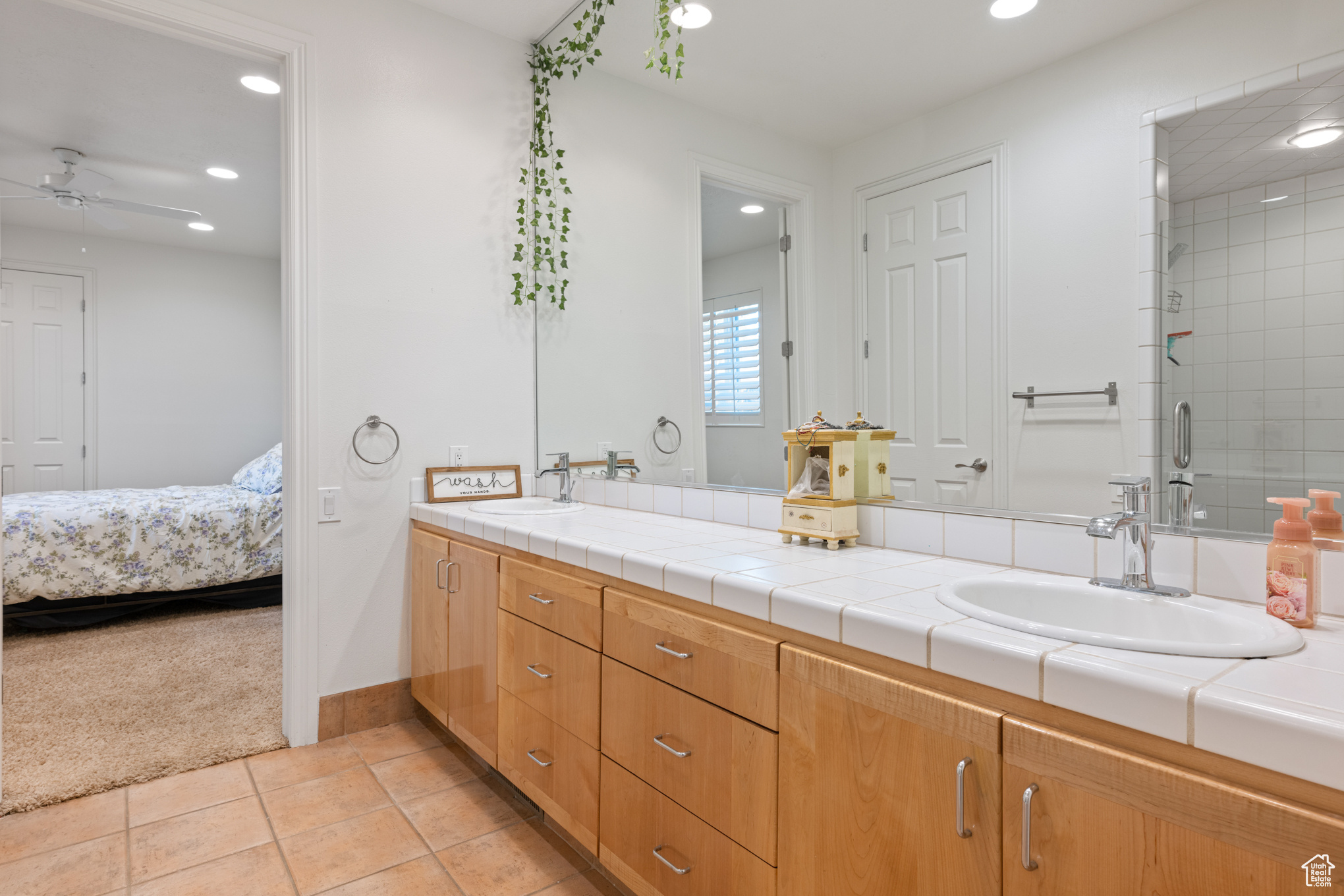 Bathroom featuring tile patterned flooring, vanity, a shower with door, and ceiling fan