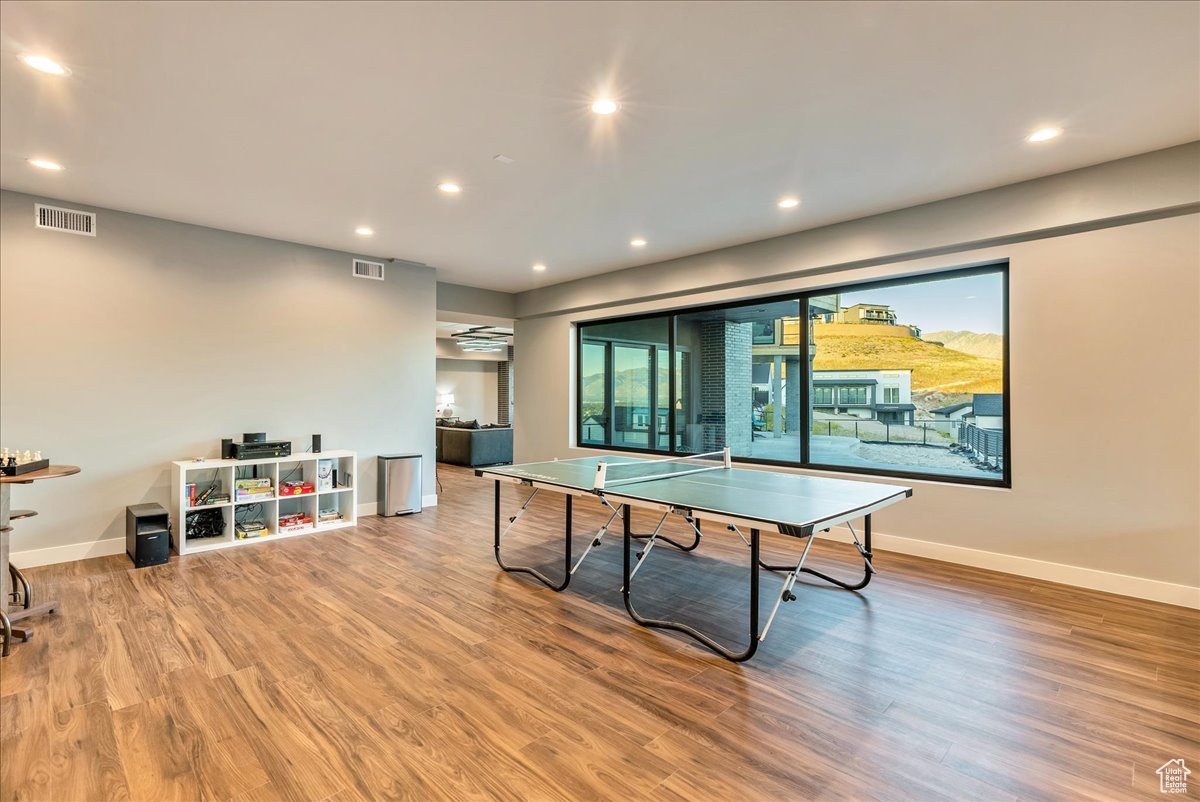 Recreation room with hardwood / wood-style flooring