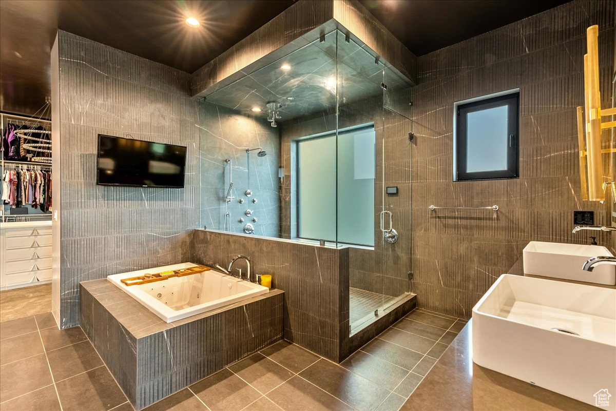 Bathroom featuring tile patterned floors, independent shower and bath, and tile walls