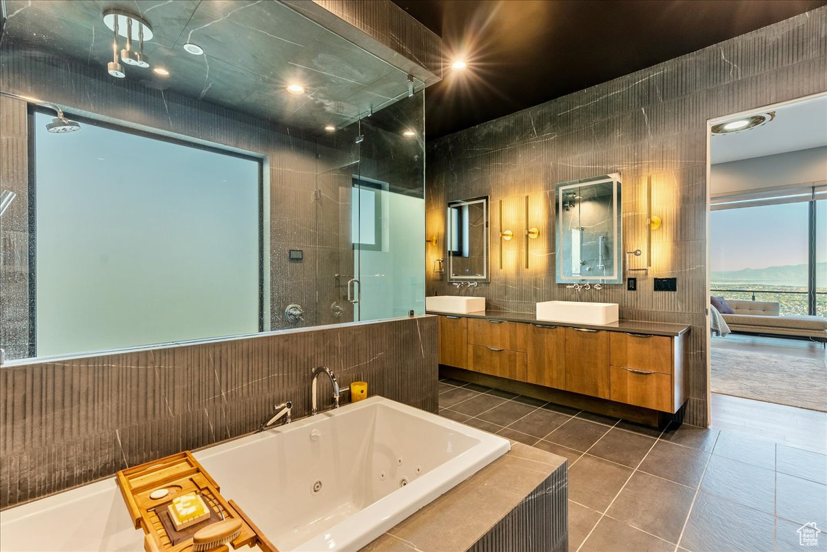 Bathroom featuring tile patterned floors, separate shower and tub, vanity, and tile walls