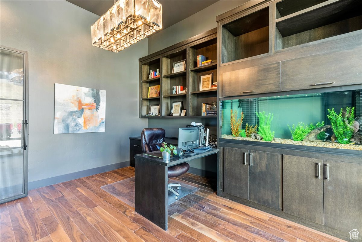 Office area featuring wood-type flooring and a chandelier