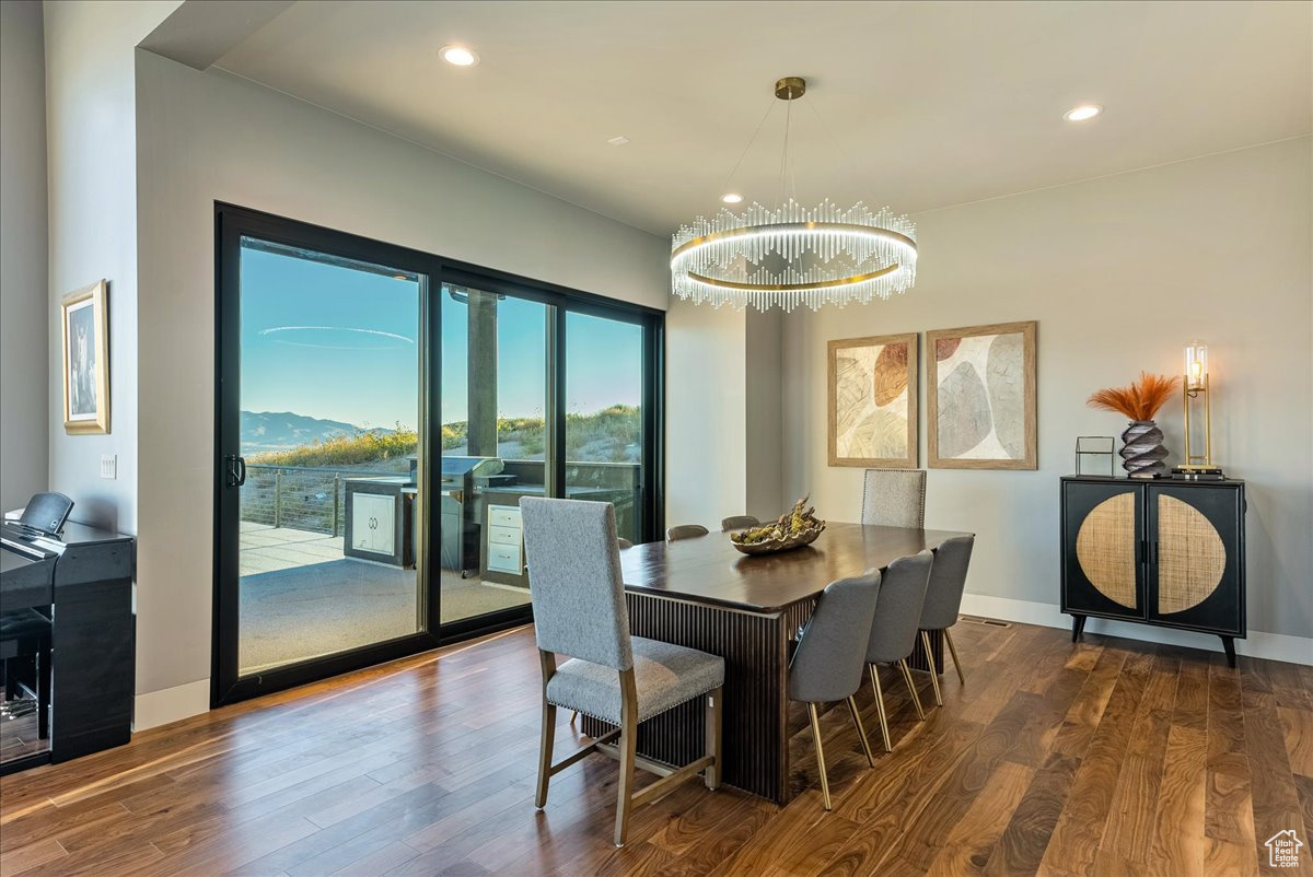 Dining room featuring a mountain view, dark wood-type flooring, and a notable chandelier