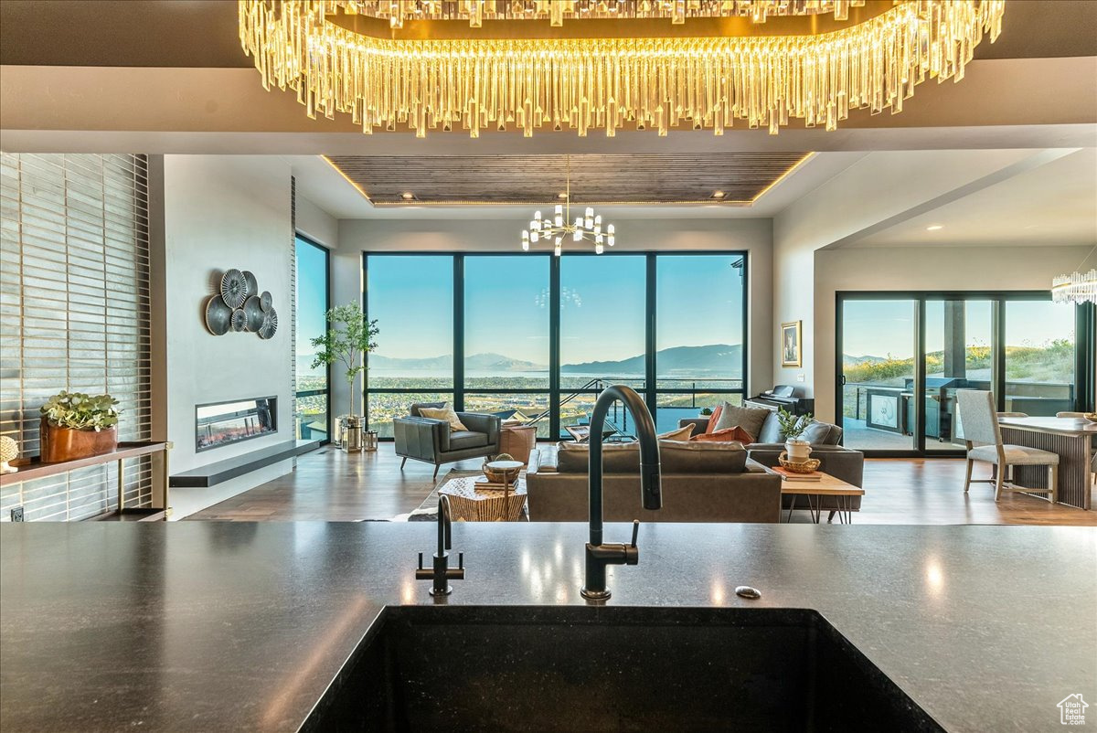 Interior space featuring a mountain view, a tray ceiling, a chandelier, and sink