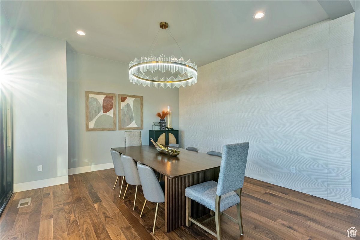 Dining space with dark hardwood / wood-style flooring and a chandelier