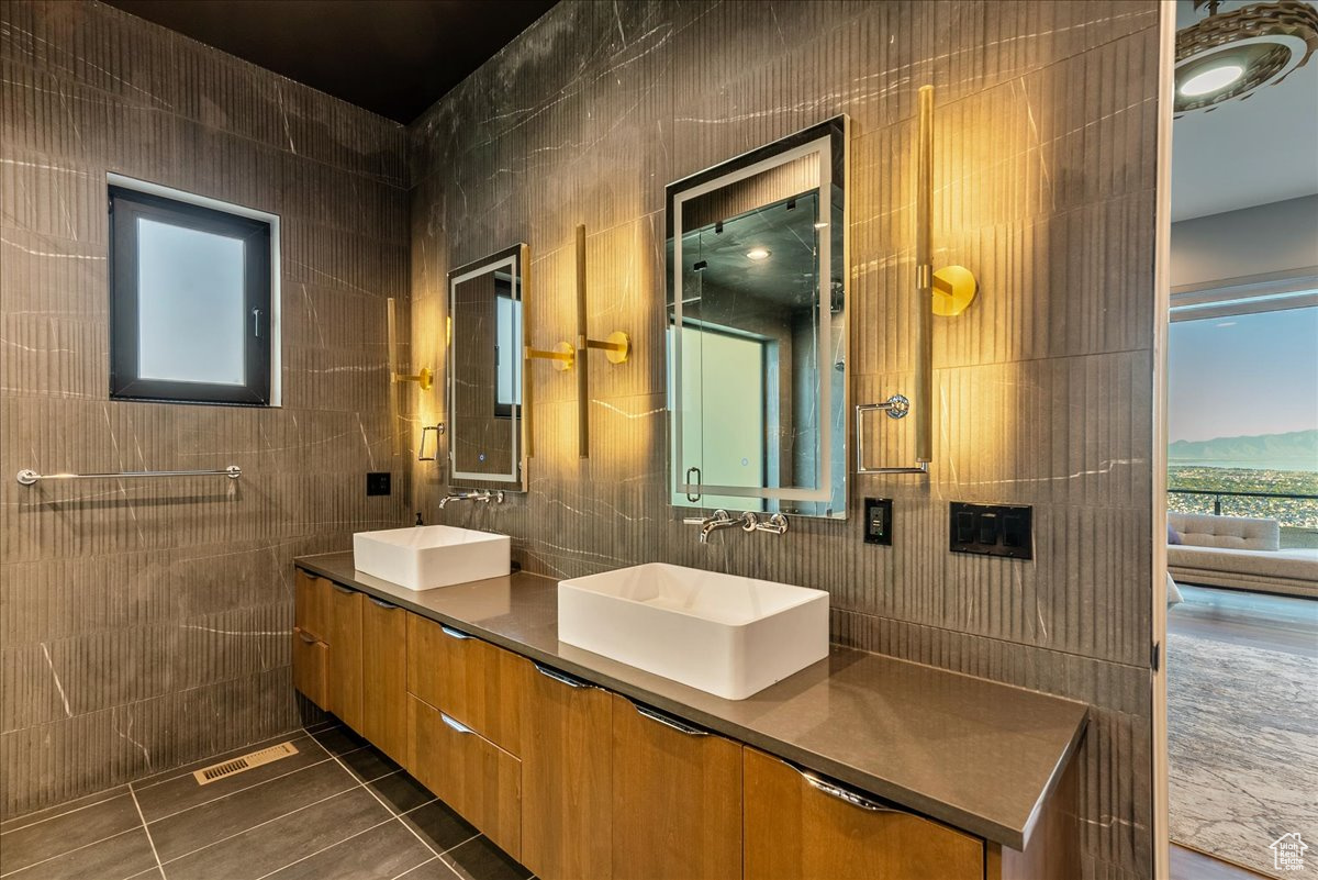 Bathroom featuring tile patterned floors, vanity, and tile walls