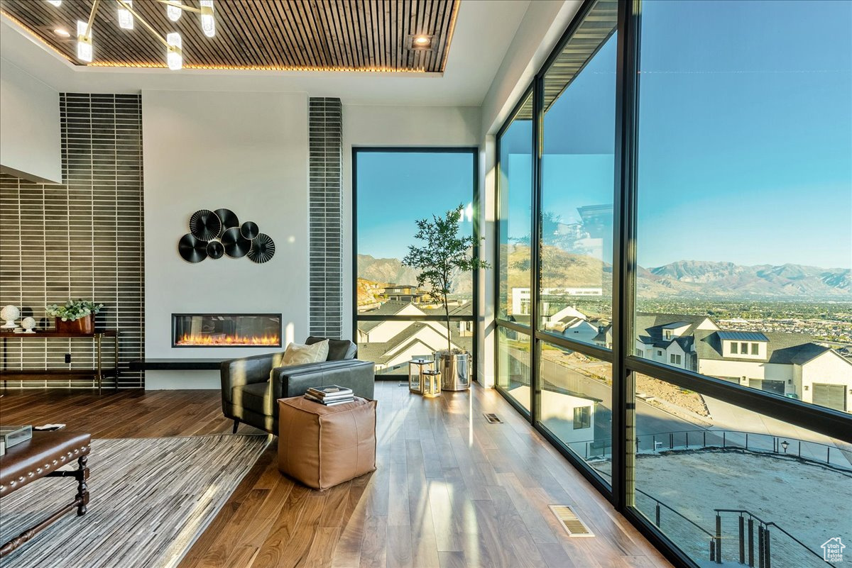 Sunroom featuring a raised ceiling and a mountain view