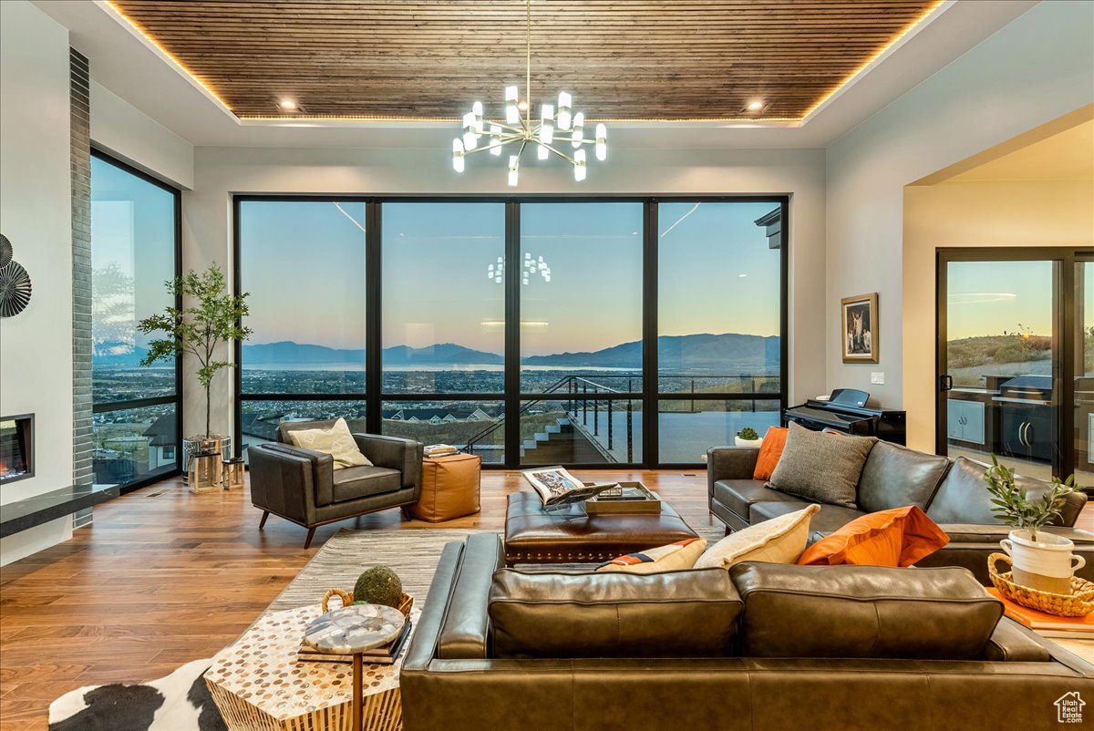 Living room featuring a notable chandelier, a mountain view, wood ceiling, and light hardwood / wood-style flooring