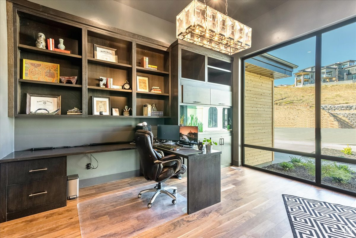 Home office featuring built in desk and light wood-type flooring