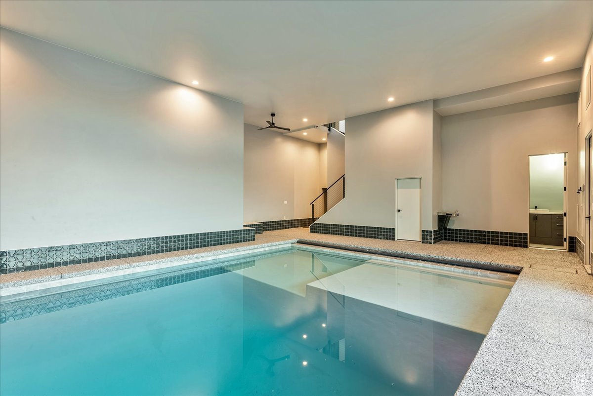 View of swimming pool featuring ceiling fan