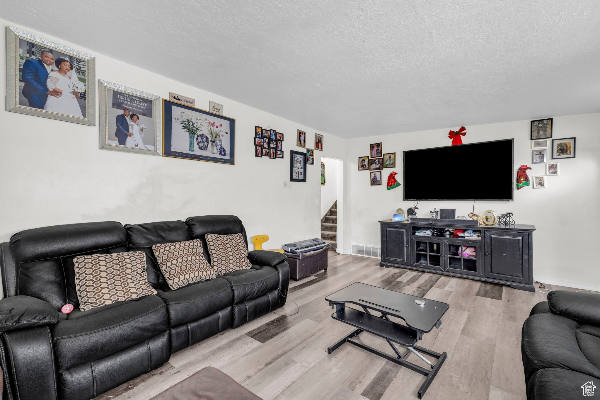 Living room featuring a textured ceiling and light hardwood / wood-style flooring