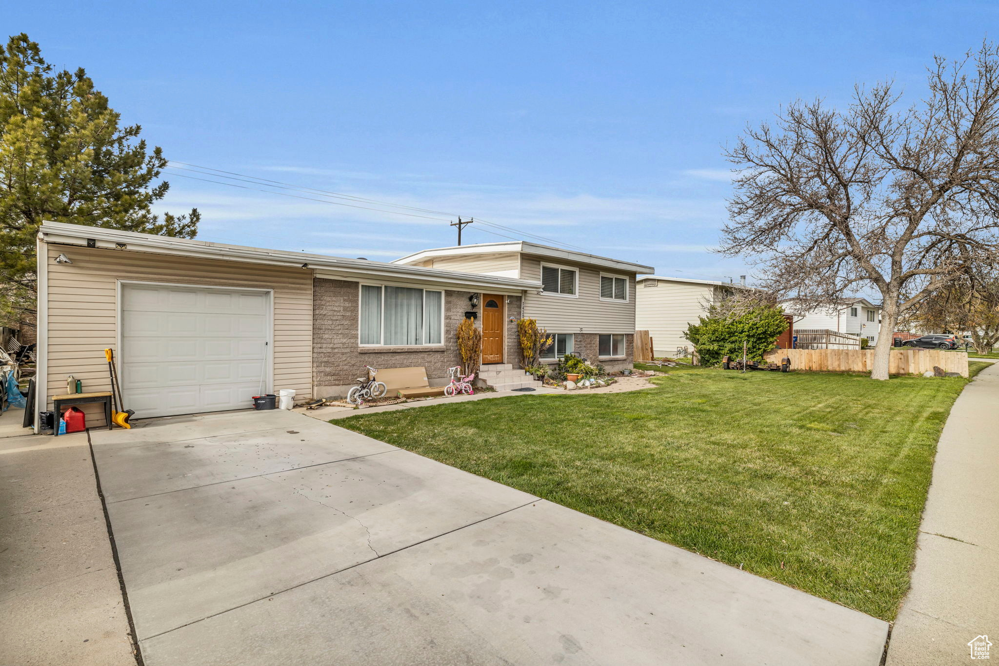 Tri-level home featuring a garage and a front lawn