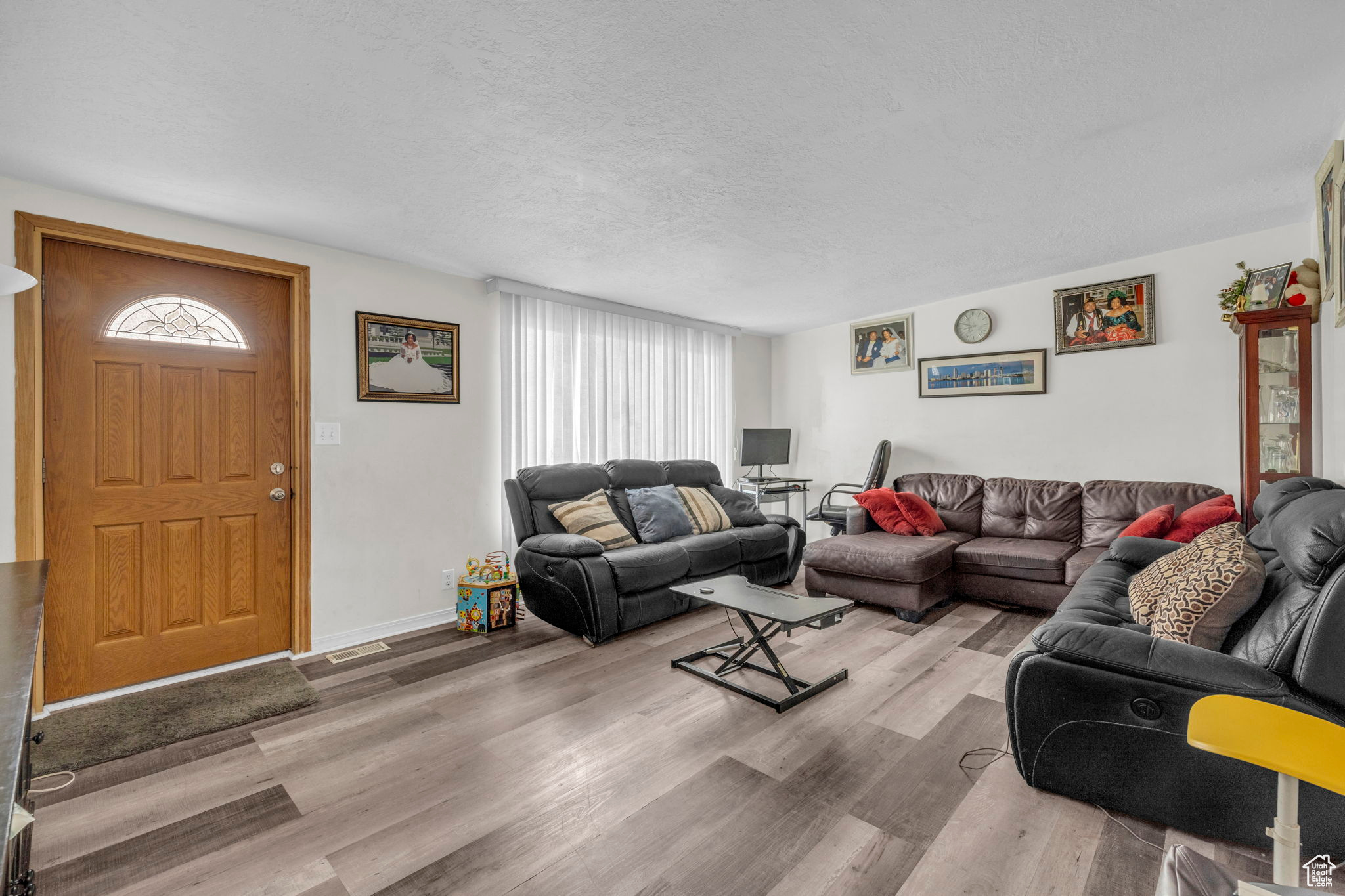 Living room with a textured ceiling and light wood-type flooring