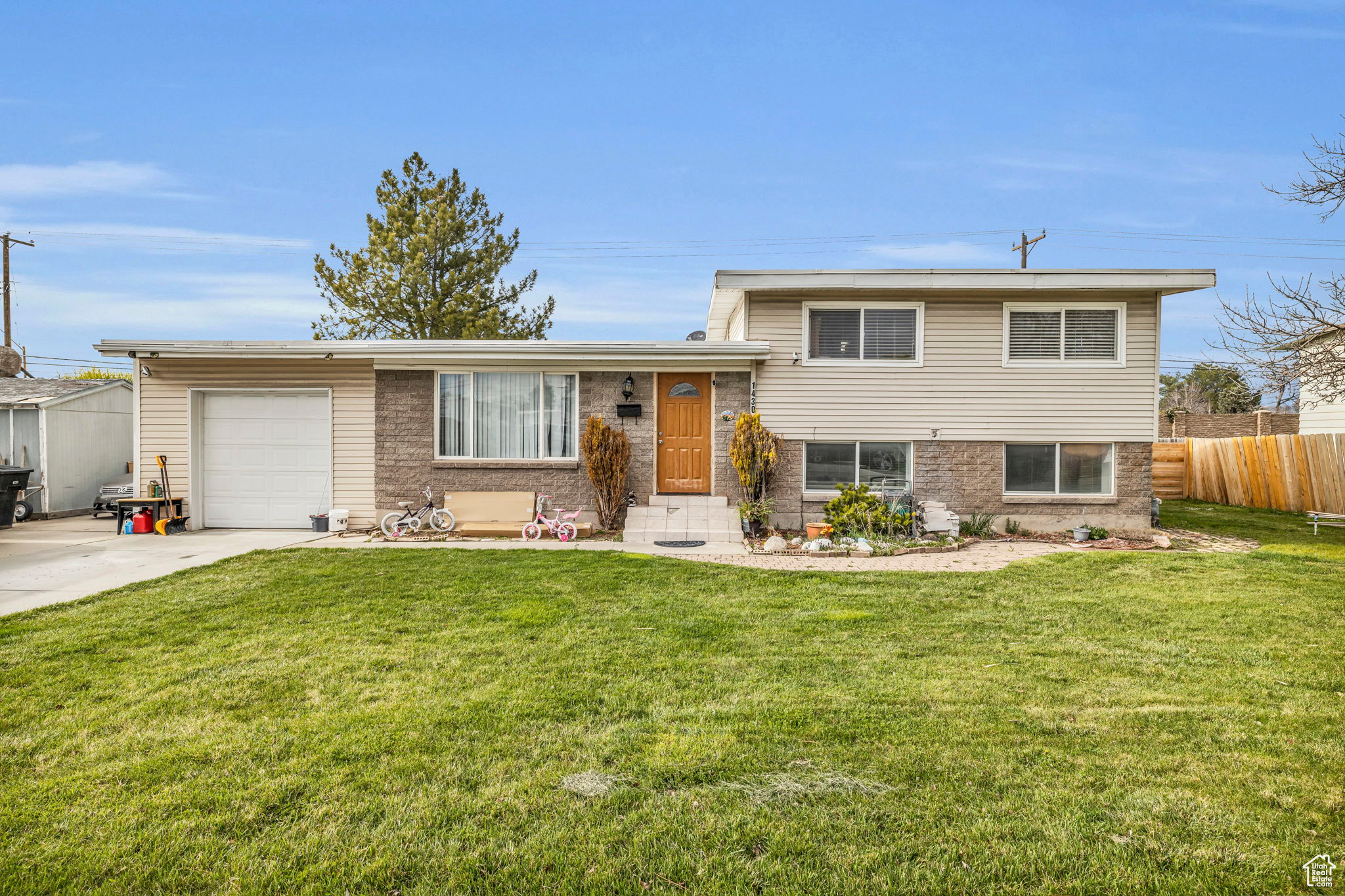 Tri-level home featuring a garage and a front yard