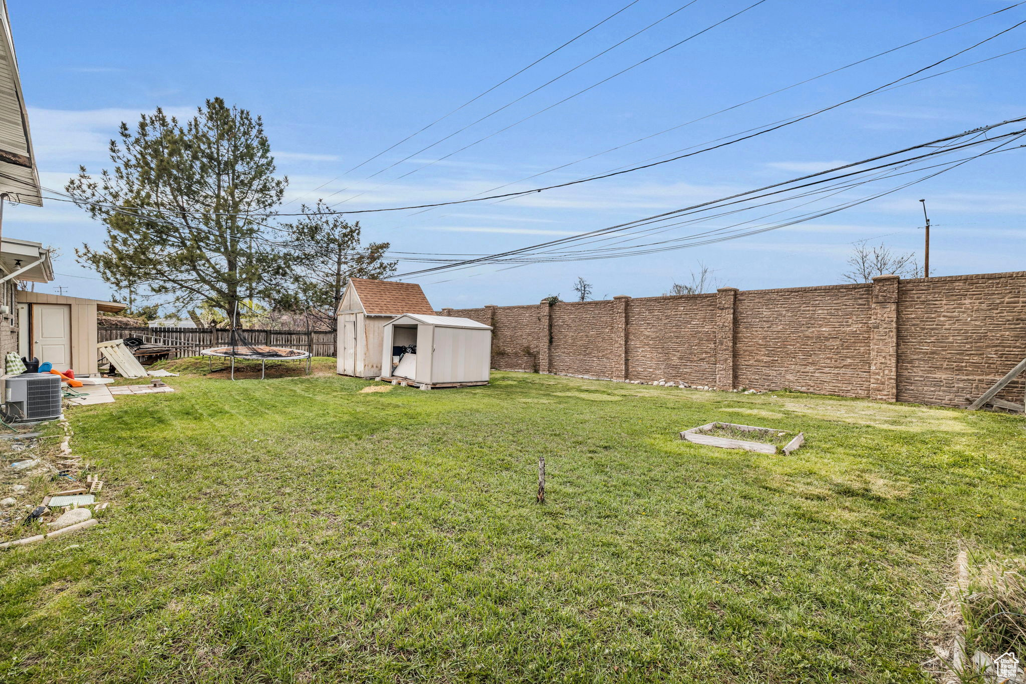 View of yard with a storage shed, central AC unit, and a trampoline