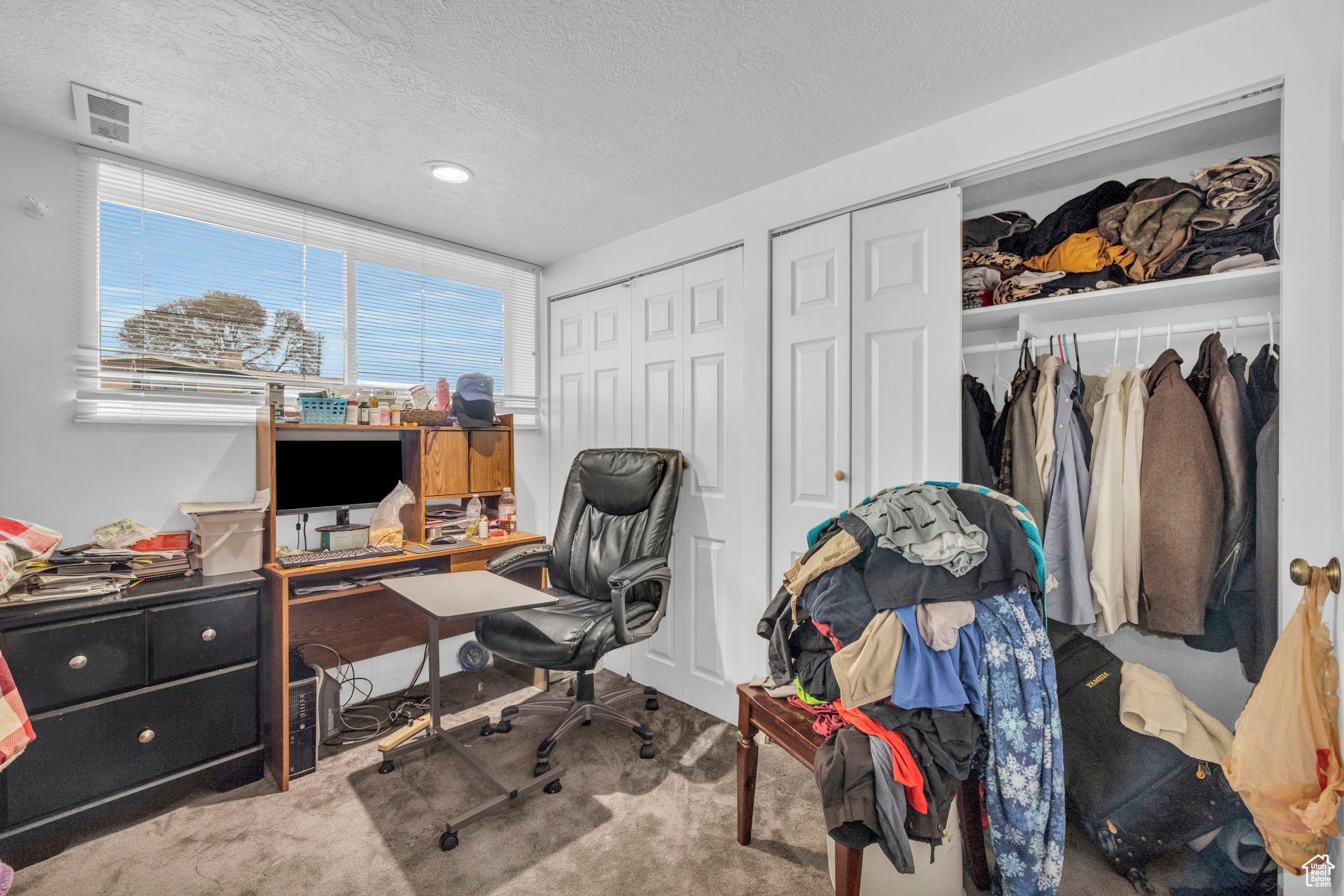 Carpeted office featuring a textured ceiling