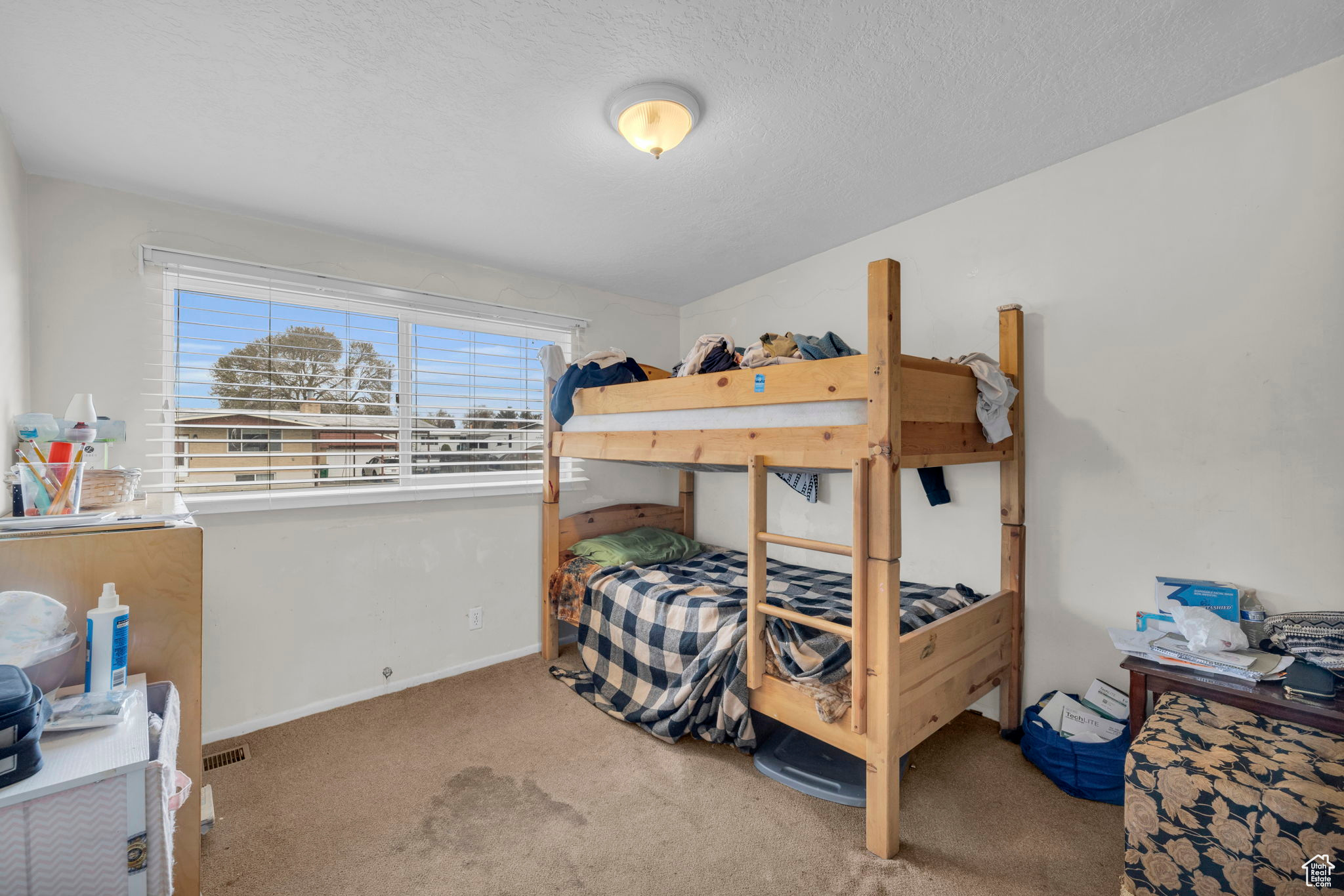 Bedroom with light carpet and a textured ceiling