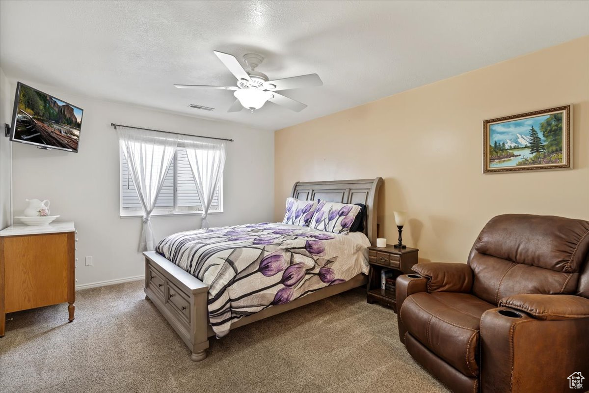 Bedroom featuring ceiling fan and light colored carpet