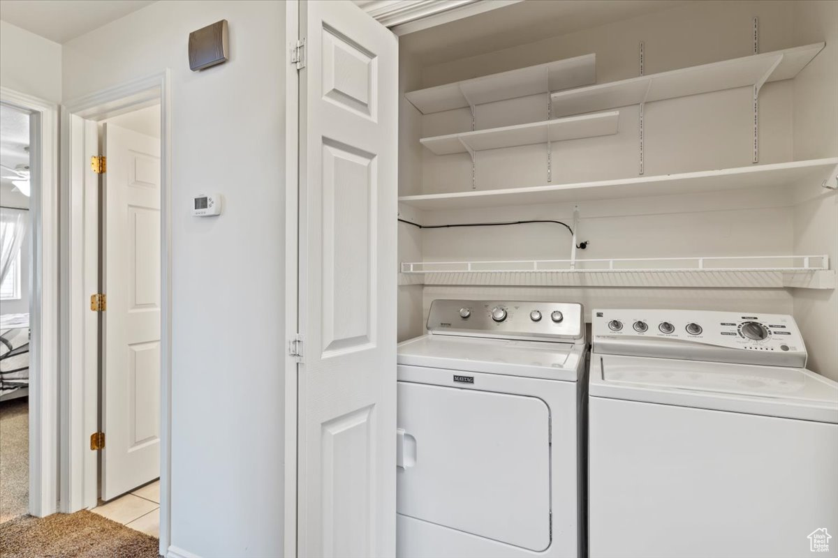 Washroom featuring light tile patterned floors and independent washer and dryer