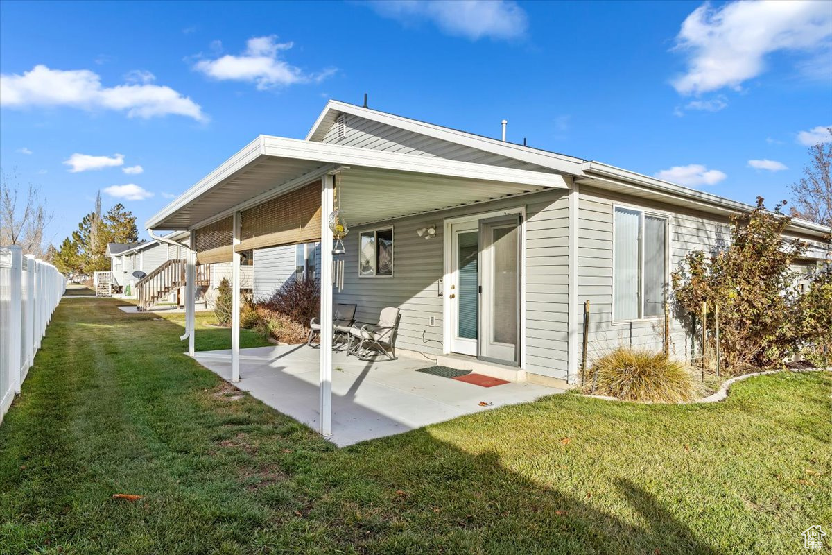 Back of property featuring a patio and a lawn