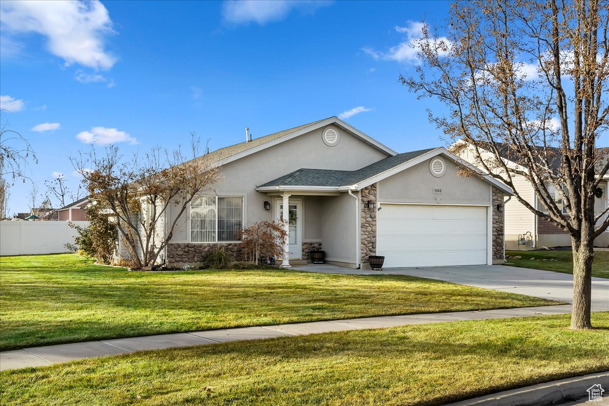 Ranch-style home with a garage and a front lawn