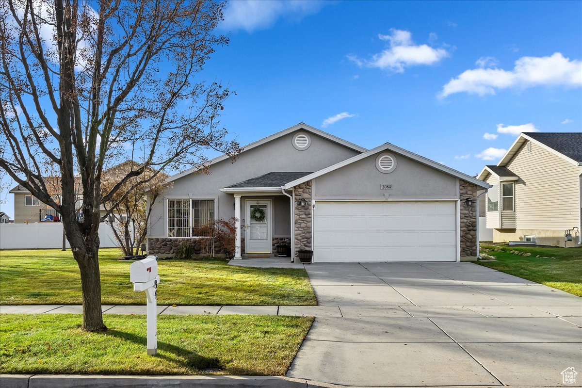 Ranch-style house with a front yard and a garage