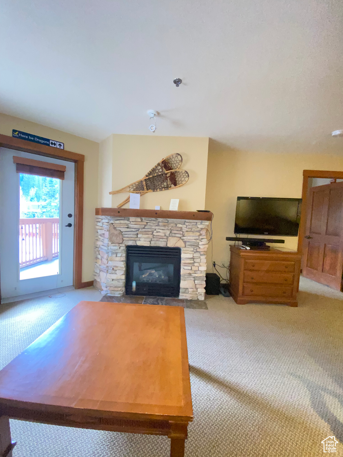 Living room with a stone fireplace and light carpet