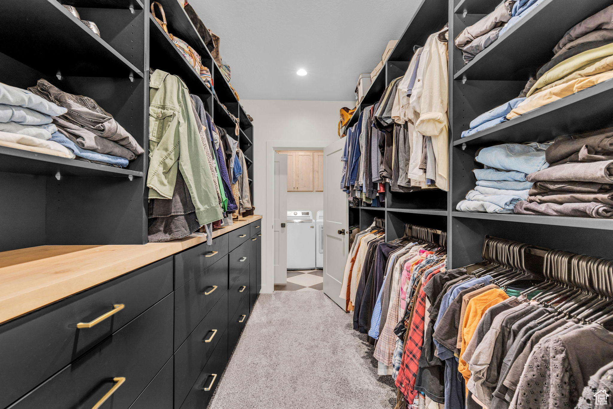 Spacious closet featuring light carpet and washer and clothes dryer