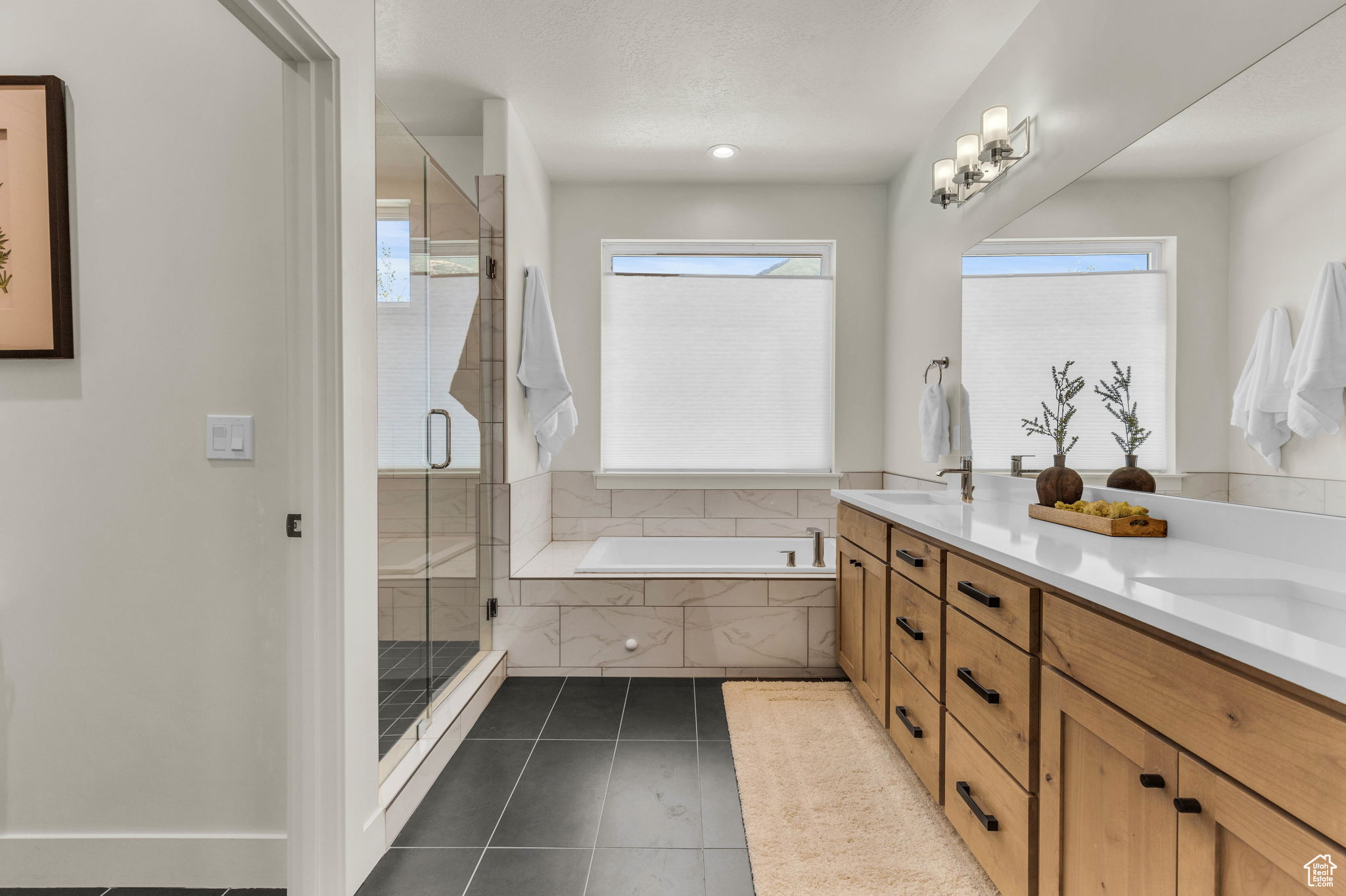 Bathroom featuring tile patterned flooring, vanity, and plus walk in shower