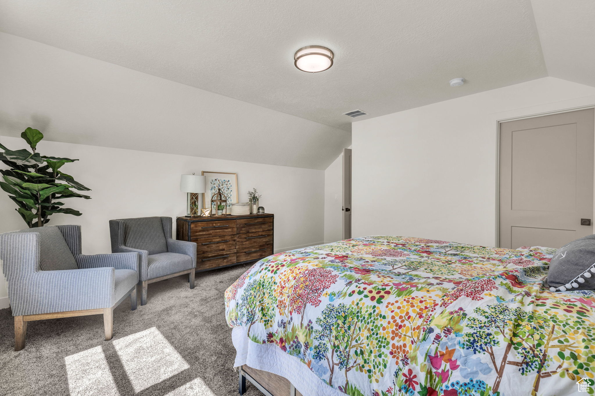 Carpeted bedroom with lofted ceiling