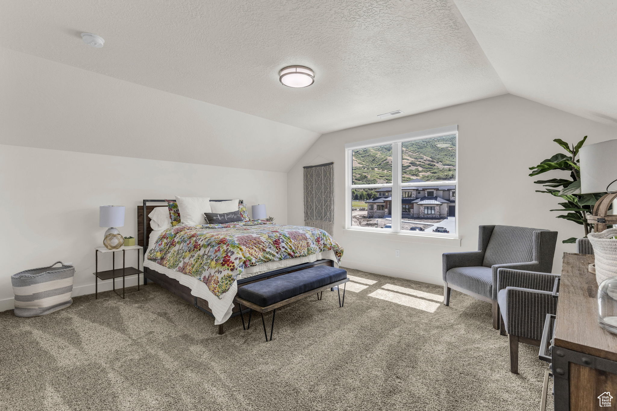 Bedroom with carpet floors, a textured ceiling, and vaulted ceiling