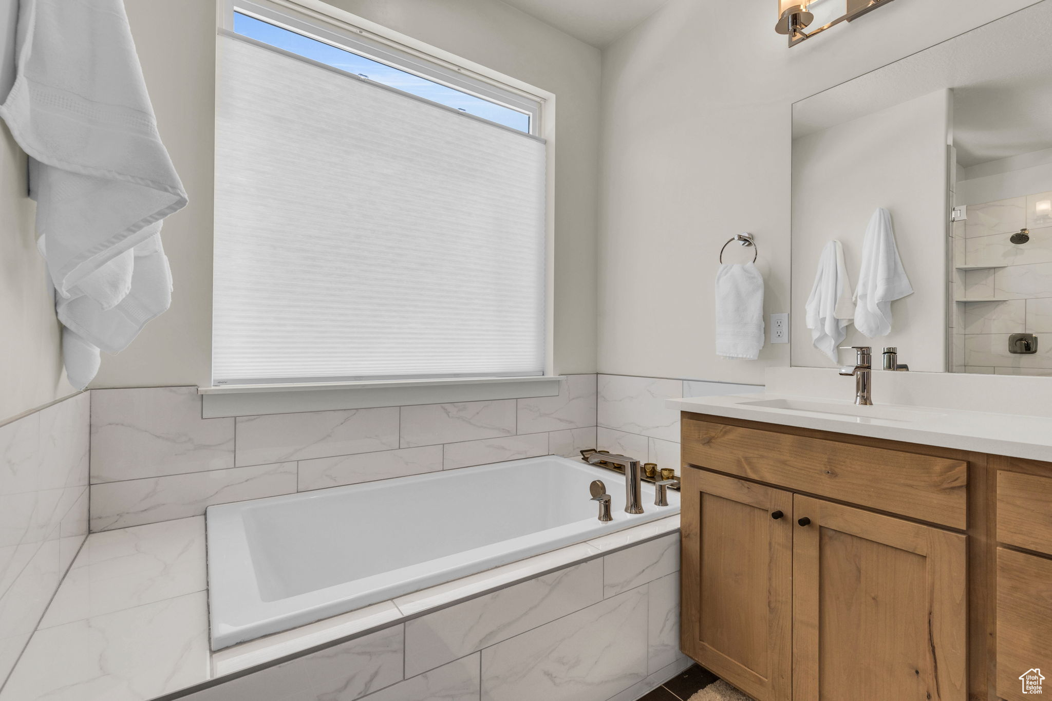 Bathroom featuring vanity and separate shower and tub