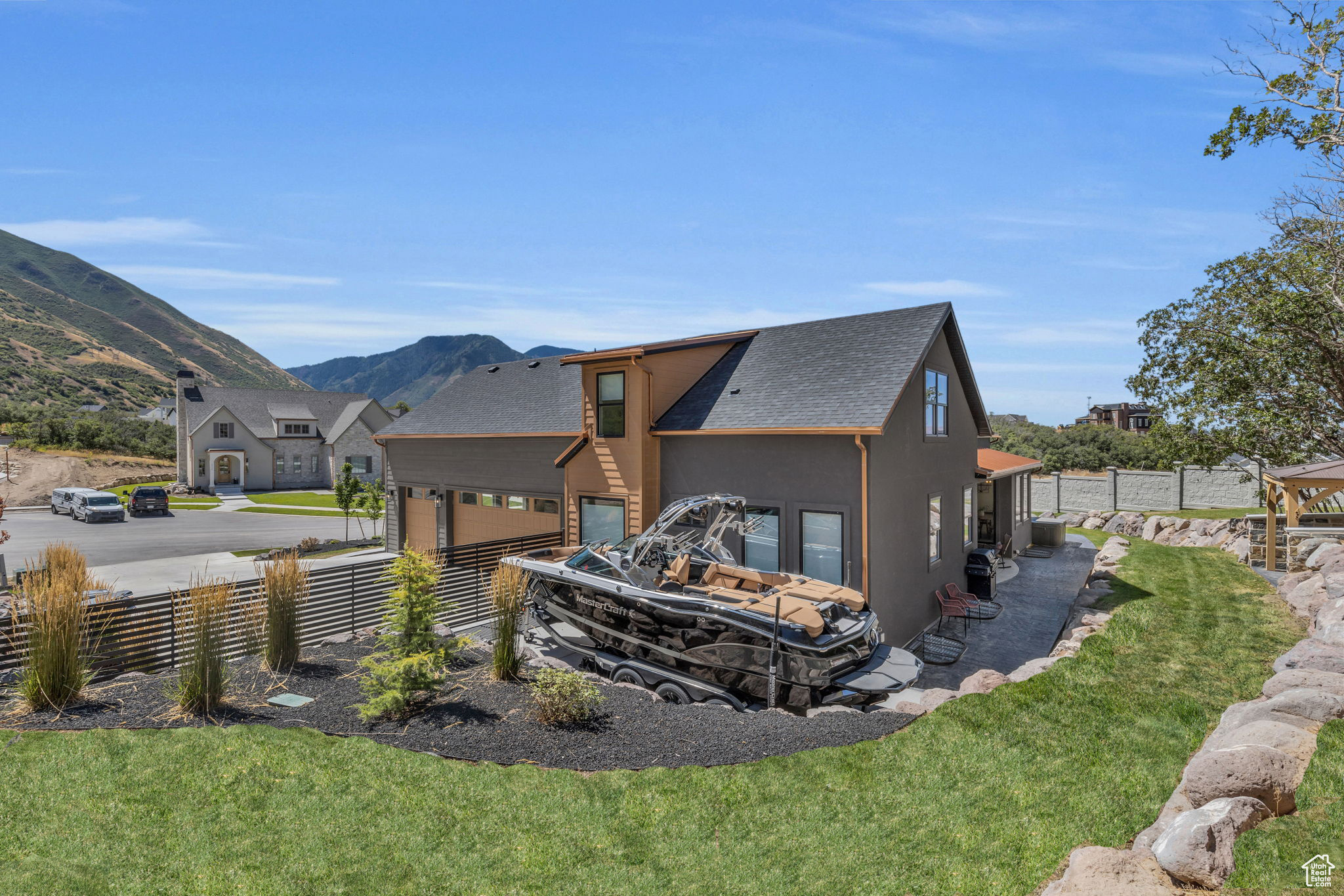 Back of property with a mountain view and a lawn