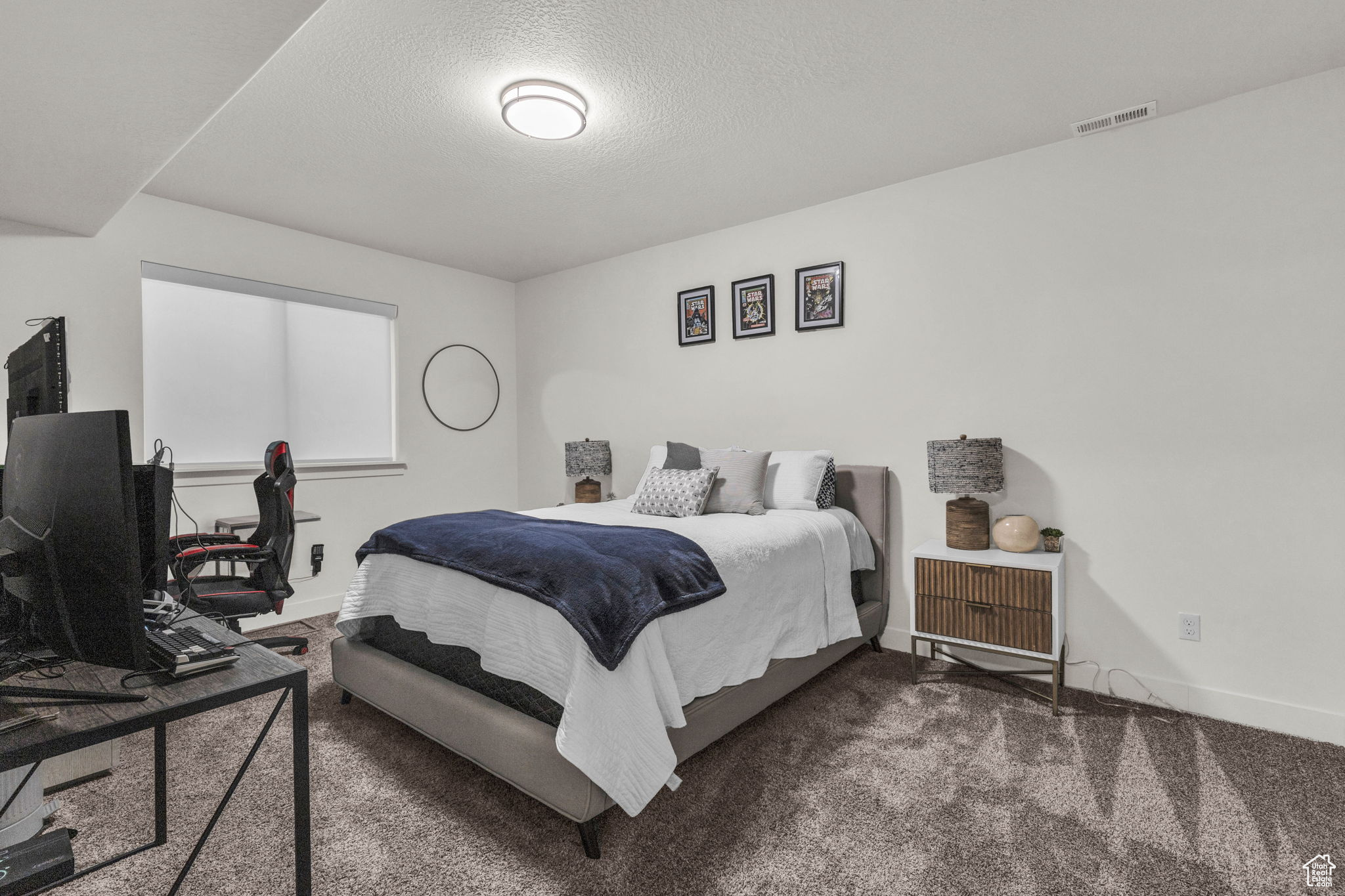 Bedroom featuring dark carpet and a textured ceiling