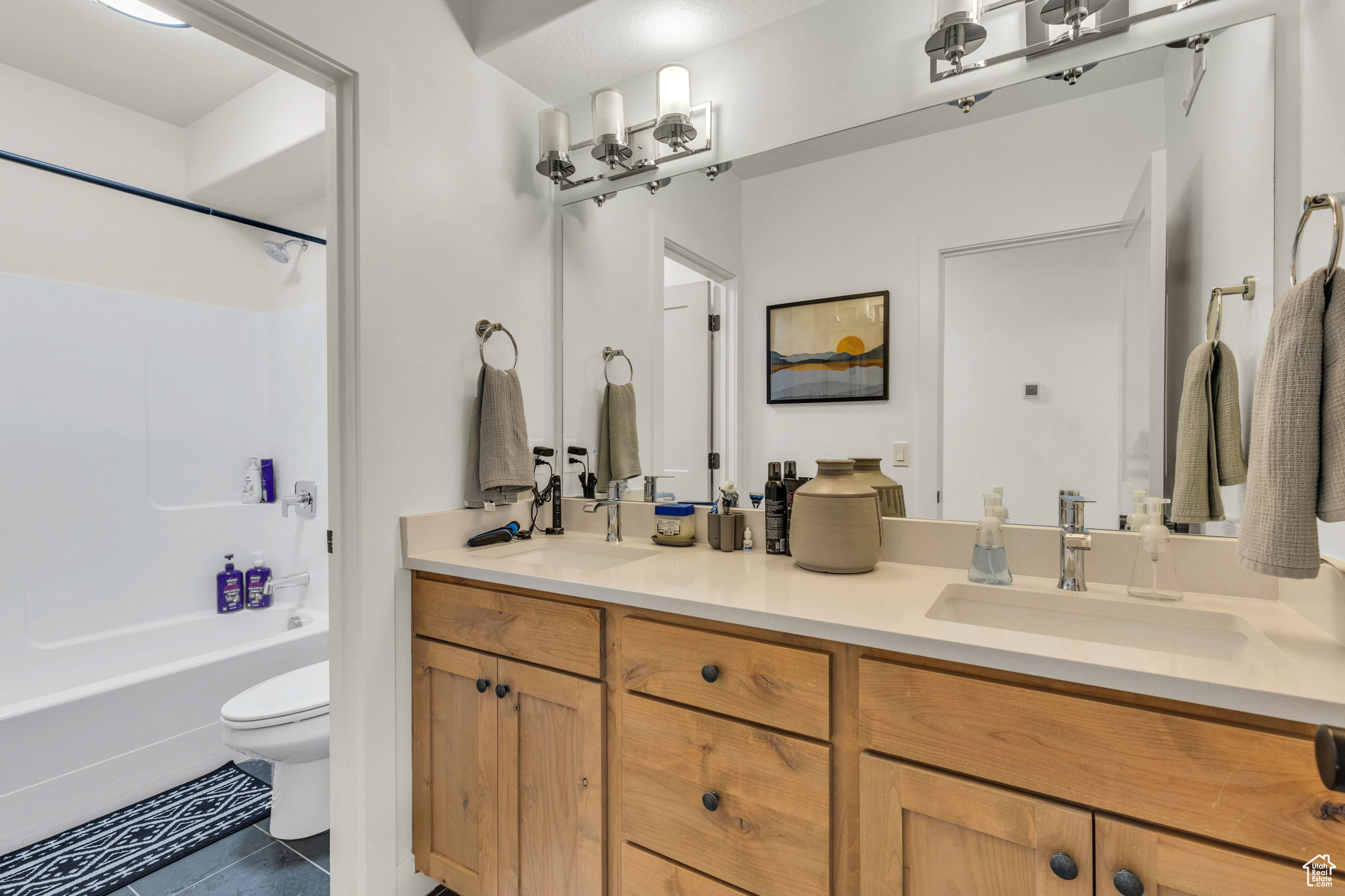 Full bathroom with washtub / shower combination, tile patterned flooring, vanity, and toilet