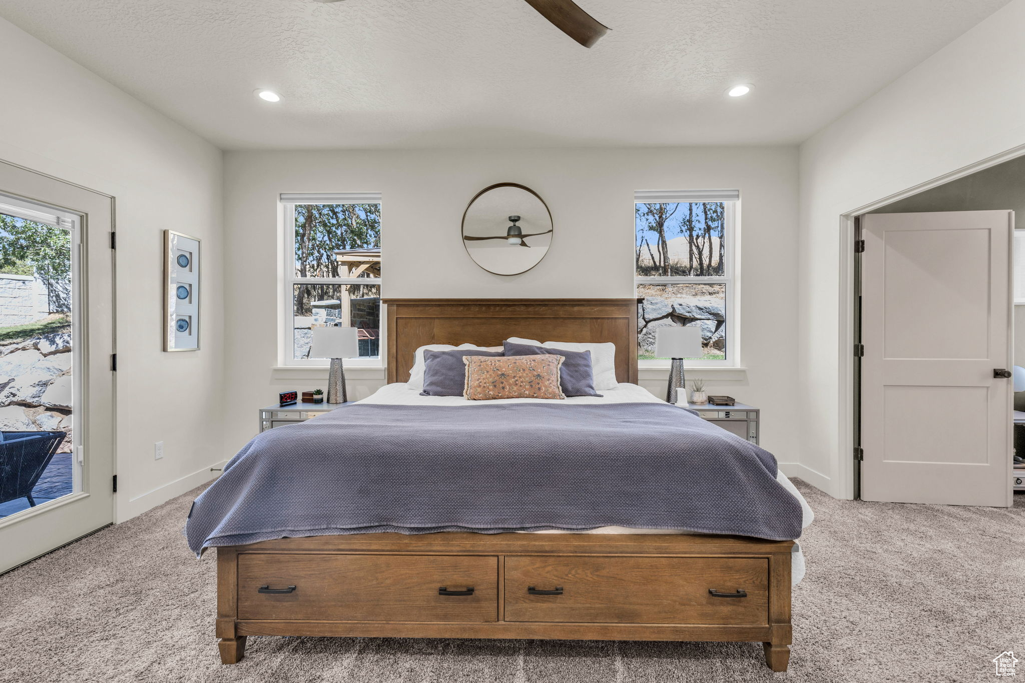 Bedroom featuring ceiling fan, light colored carpet, a textured ceiling, access to outside, and multiple windows