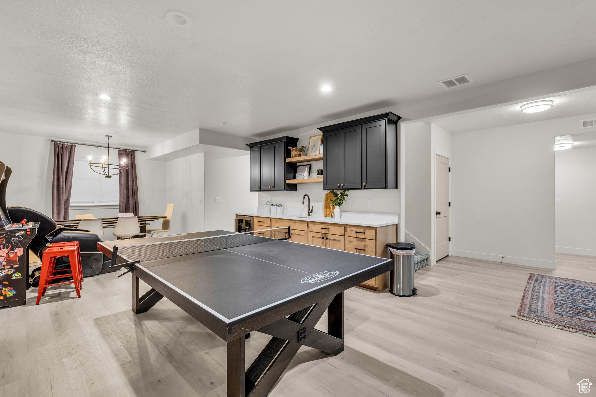 Recreation room featuring a chandelier, light hardwood / wood-style flooring, and sink