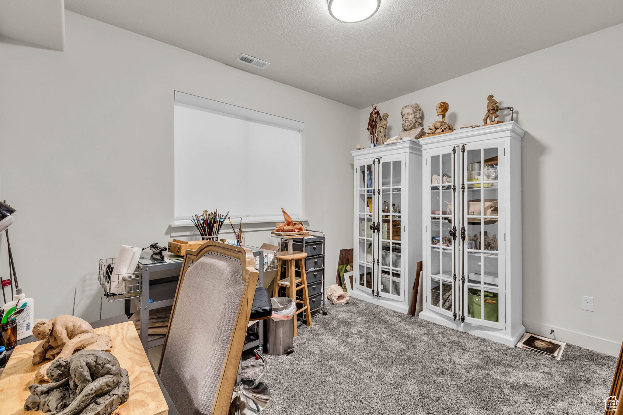 Office space featuring carpet flooring and a textured ceiling