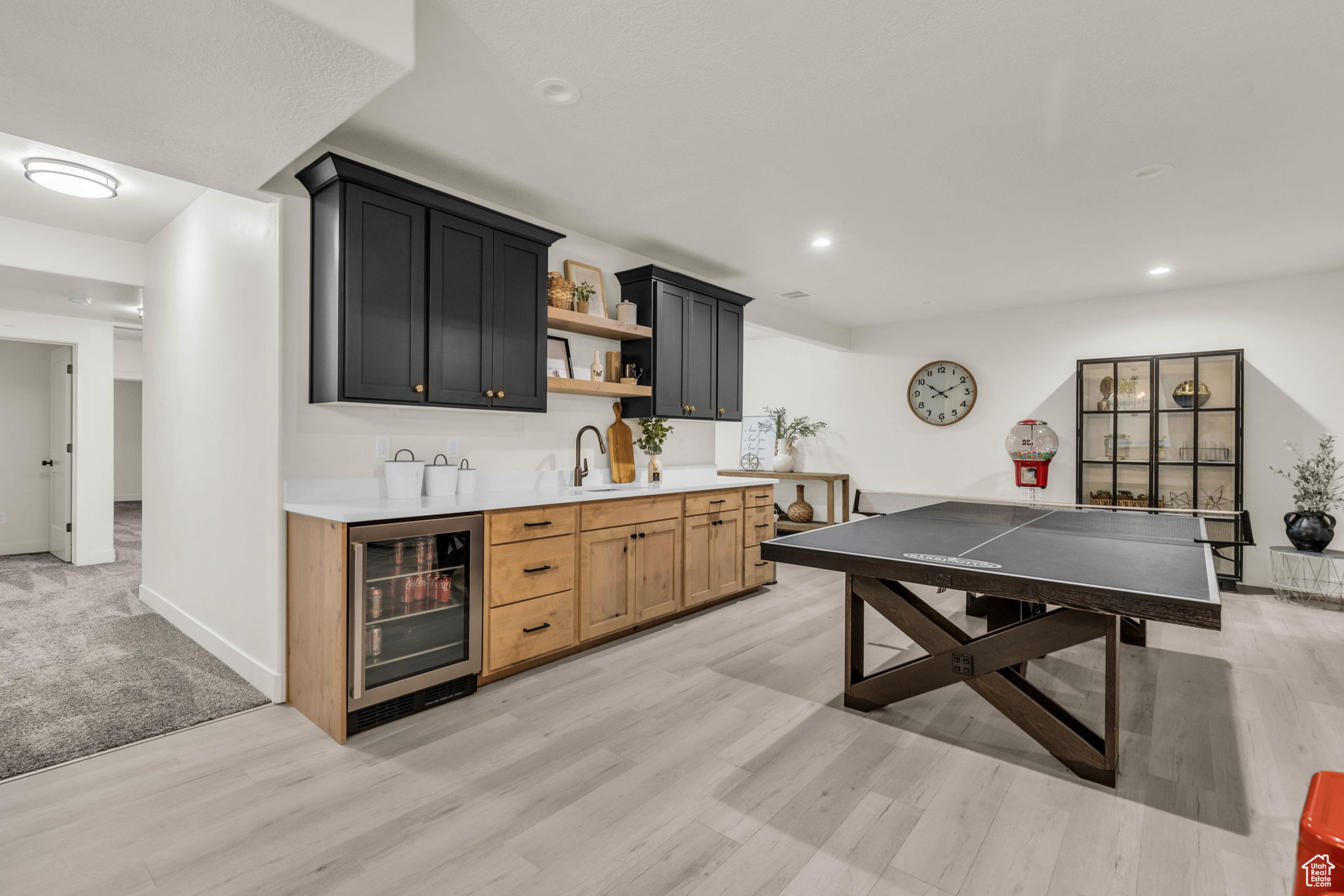 Interior space featuring light hardwood / wood-style floors, beverage cooler, and indoor wet bar