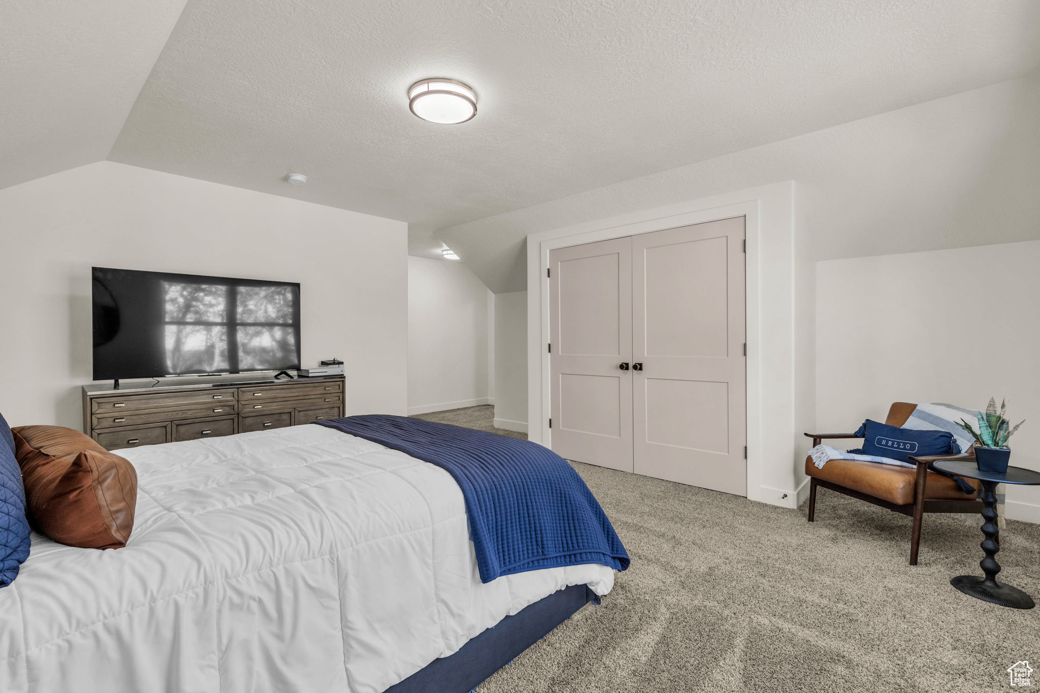 Bedroom with lofted ceiling and light carpet