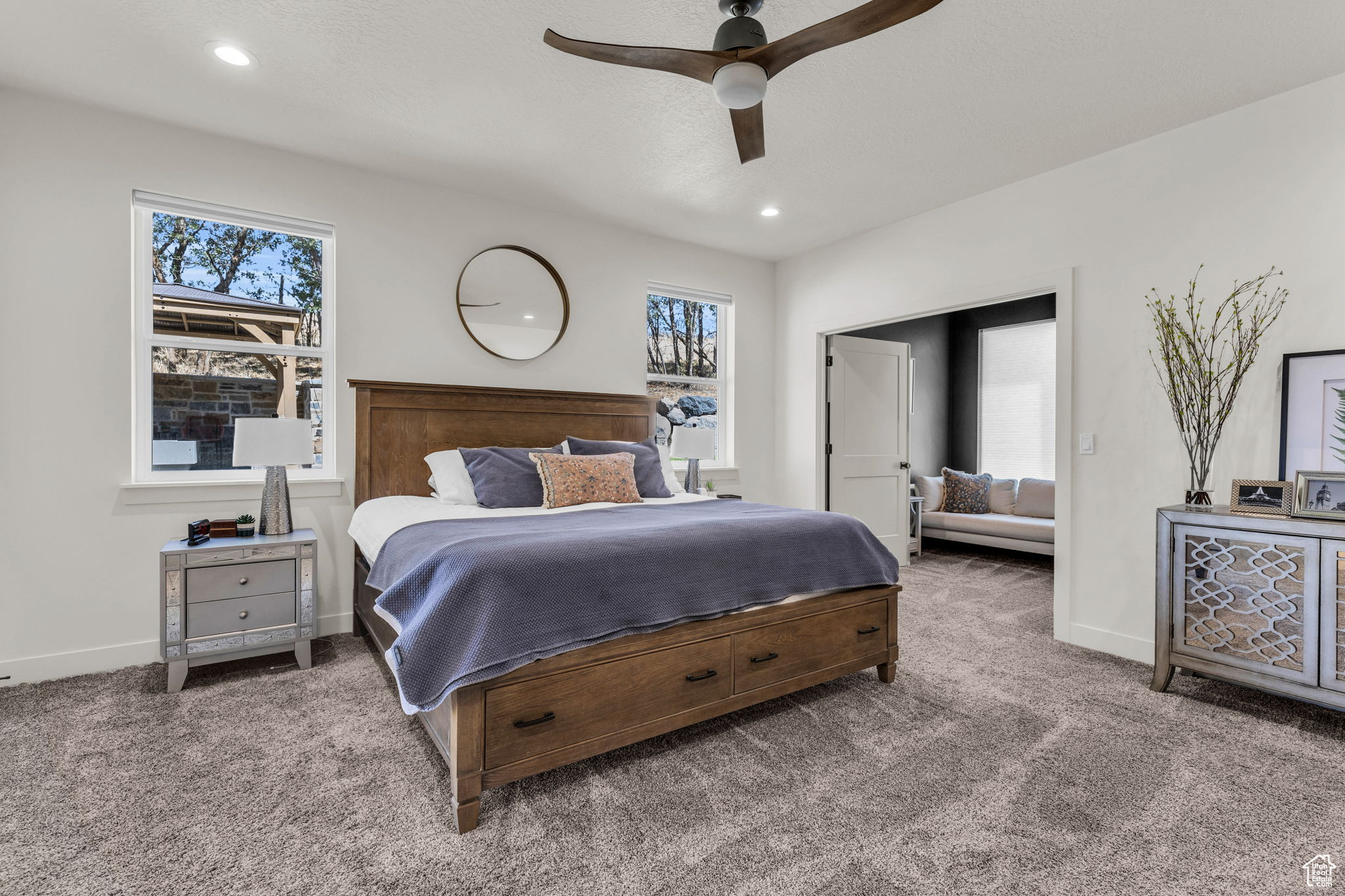 Bedroom with multiple windows, ceiling fan, and carpet floors