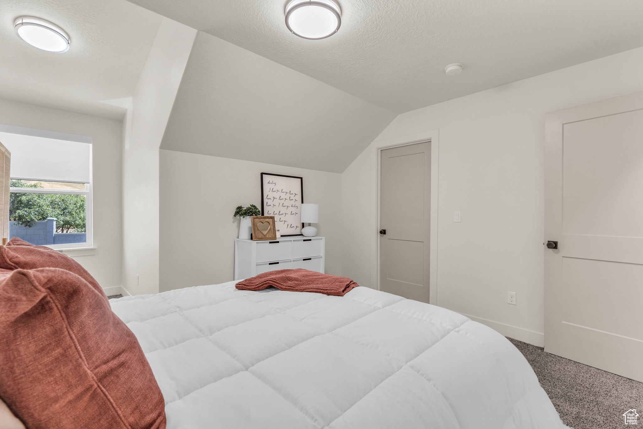 Carpeted bedroom with lofted ceiling