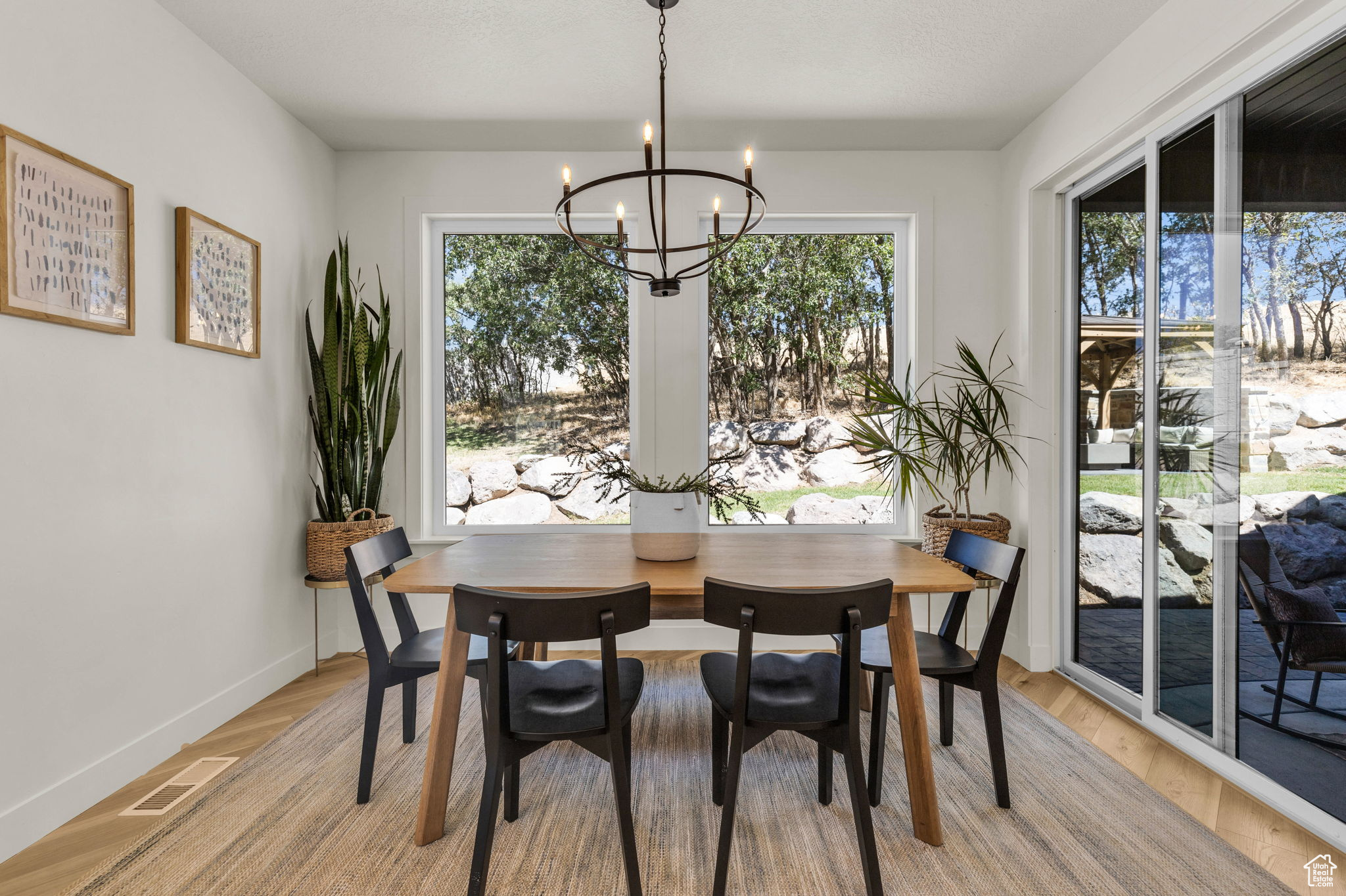 Dining area featuring light wood-type flooring and a notable chandelier