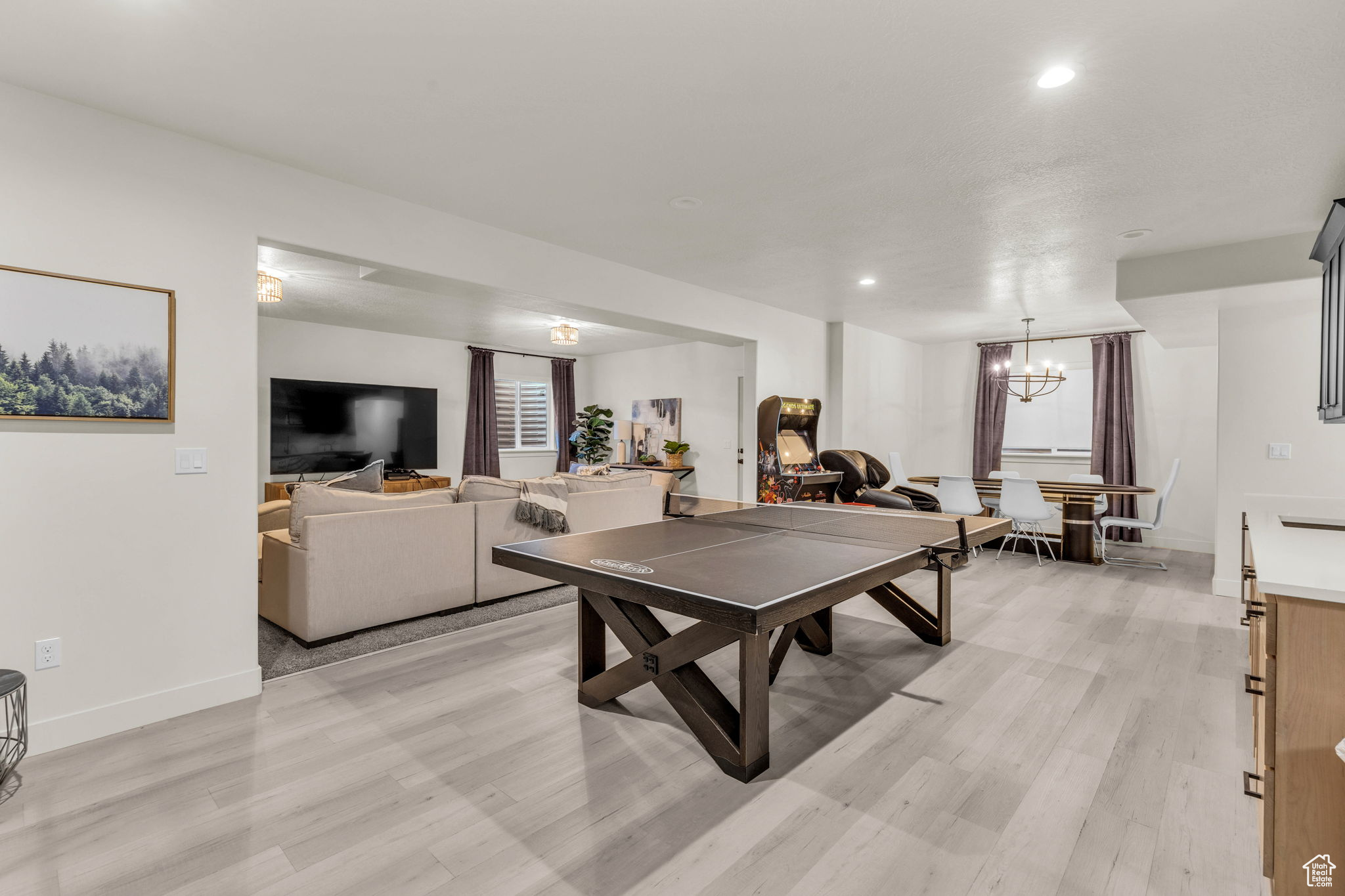 Rec room with light hardwood / wood-style flooring and a notable chandelier