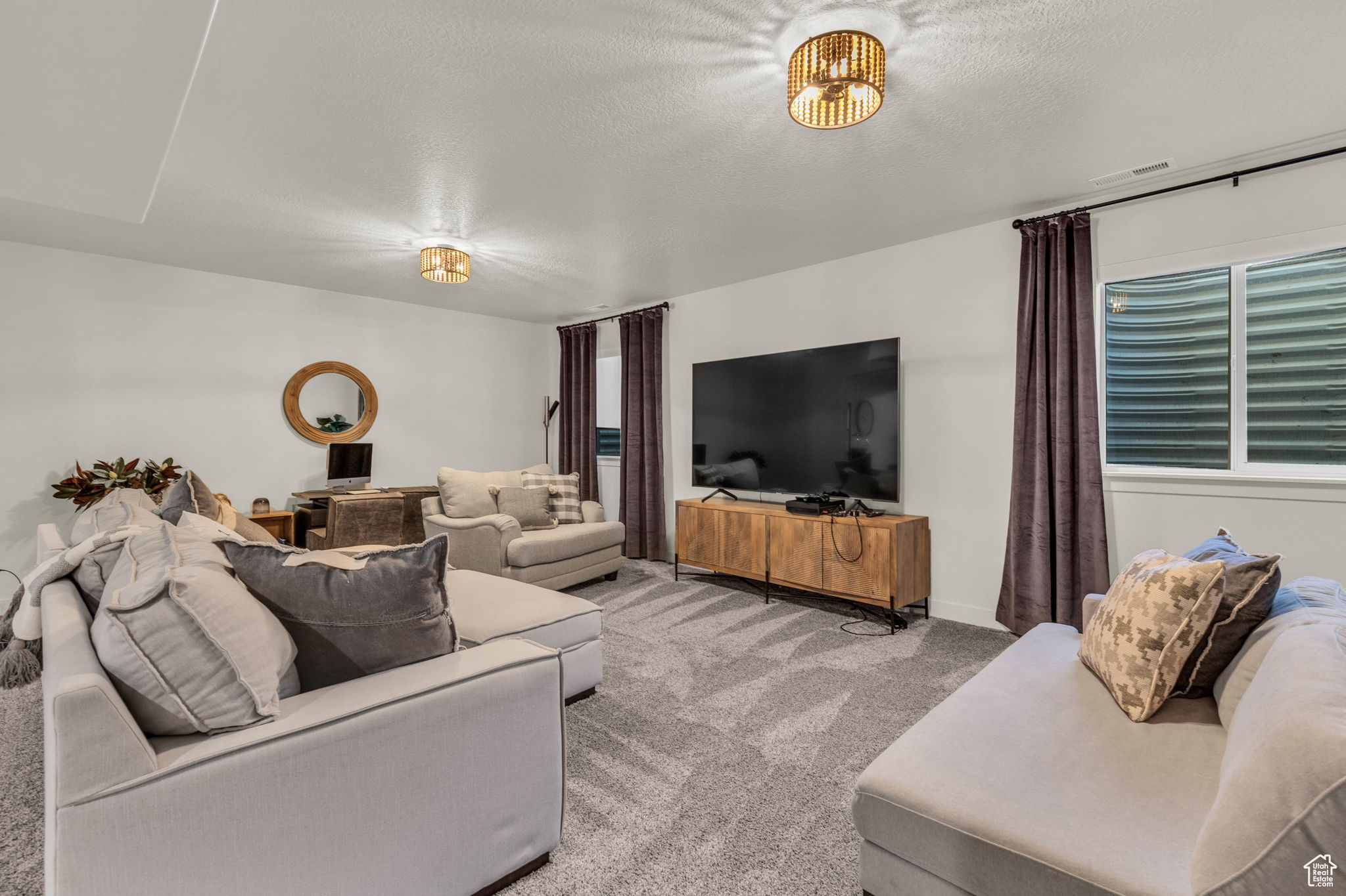 Carpeted living room featuring a healthy amount of sunlight and a textured ceiling