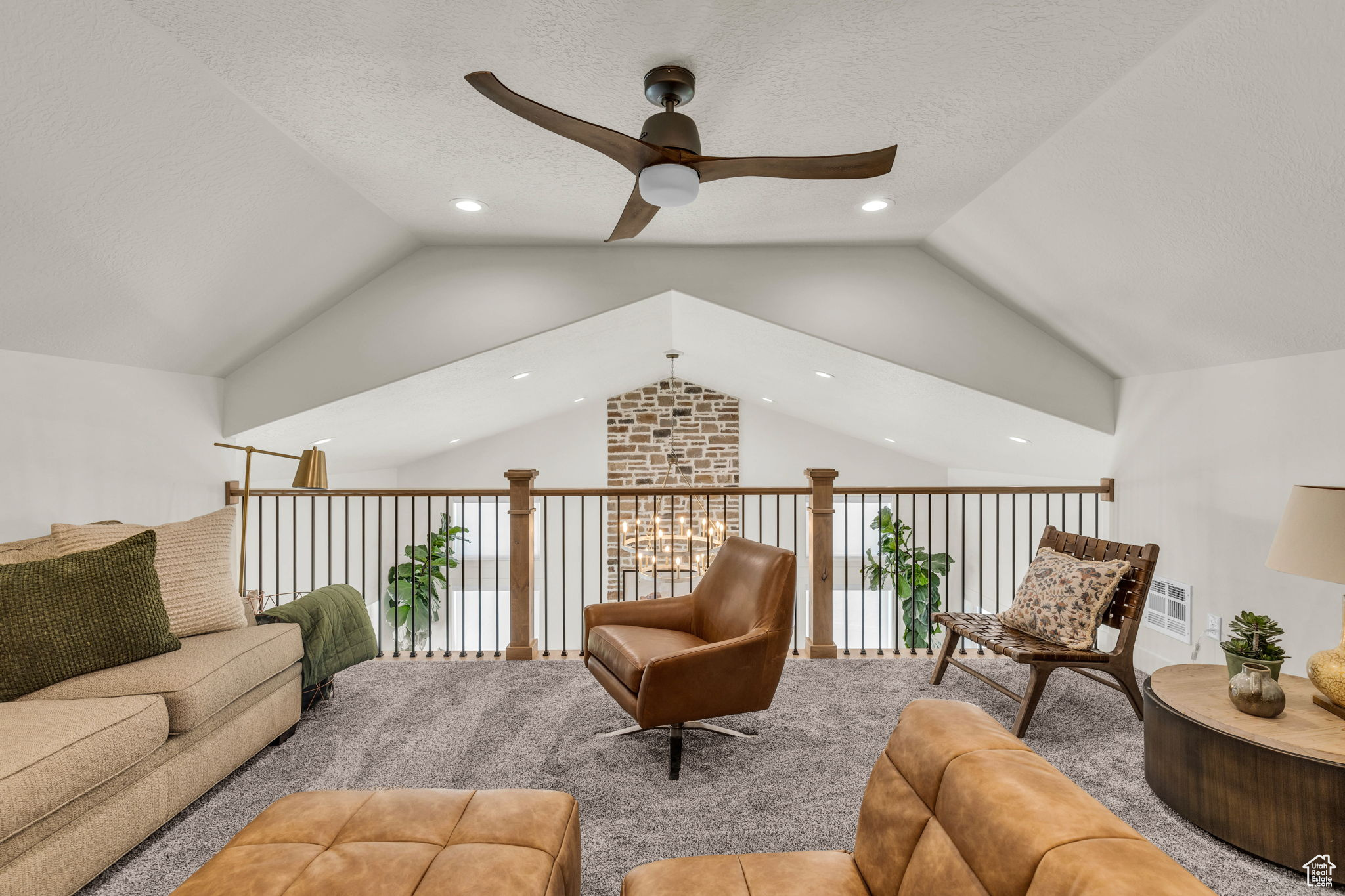 Interior space with ceiling fan, lofted ceiling, and a textured ceiling