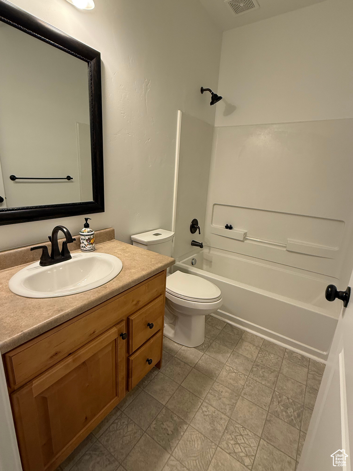 Full bathroom with vanity,  shower combination, and toilet