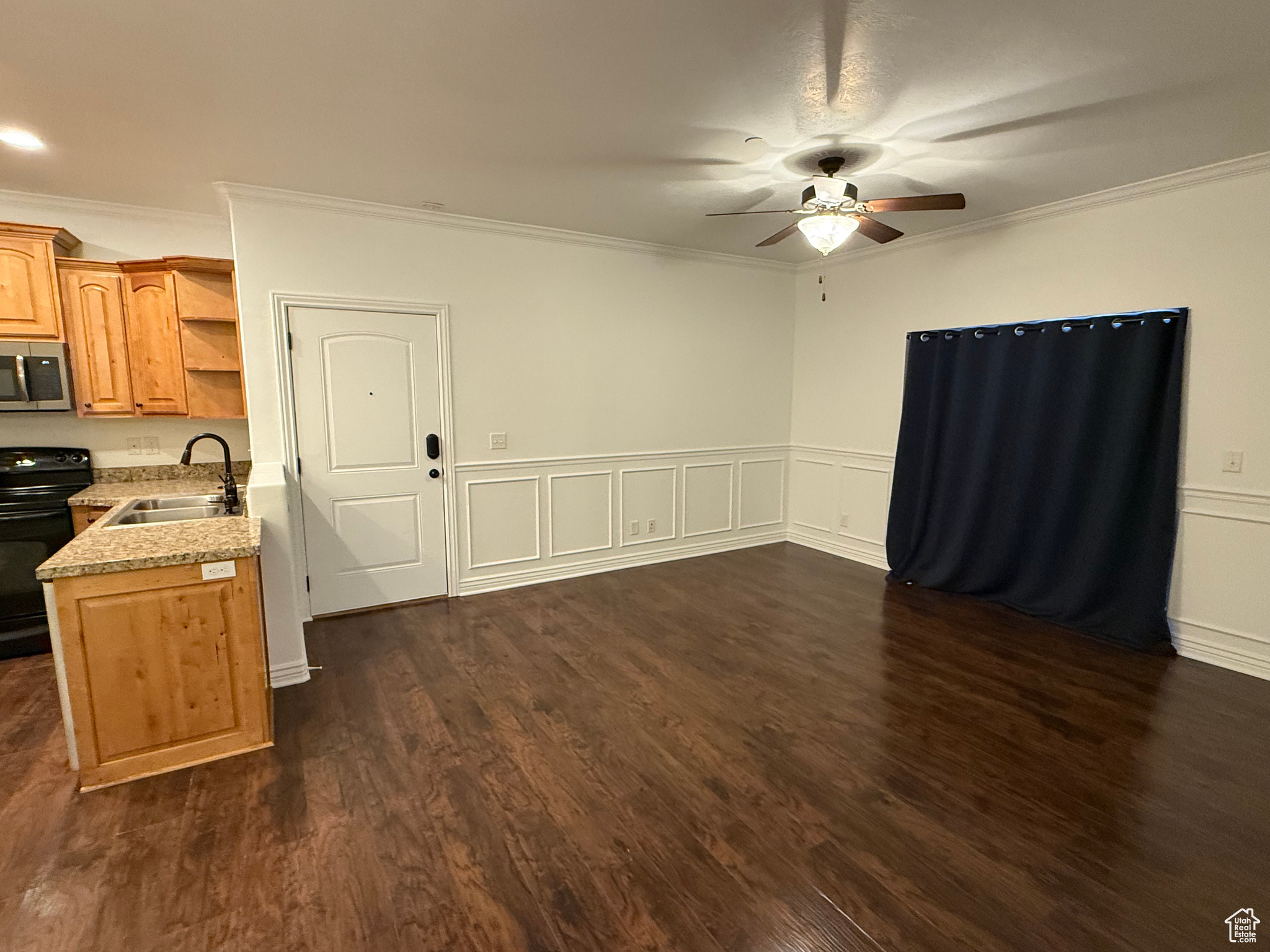 Kitchen with sink, electric range, dark hardwood / wood-style floors, ceiling fan, and ornamental molding